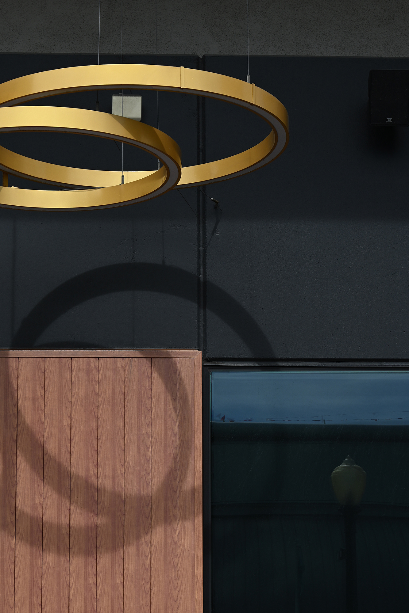 Gold Rings against a black and brown building, Long Beach