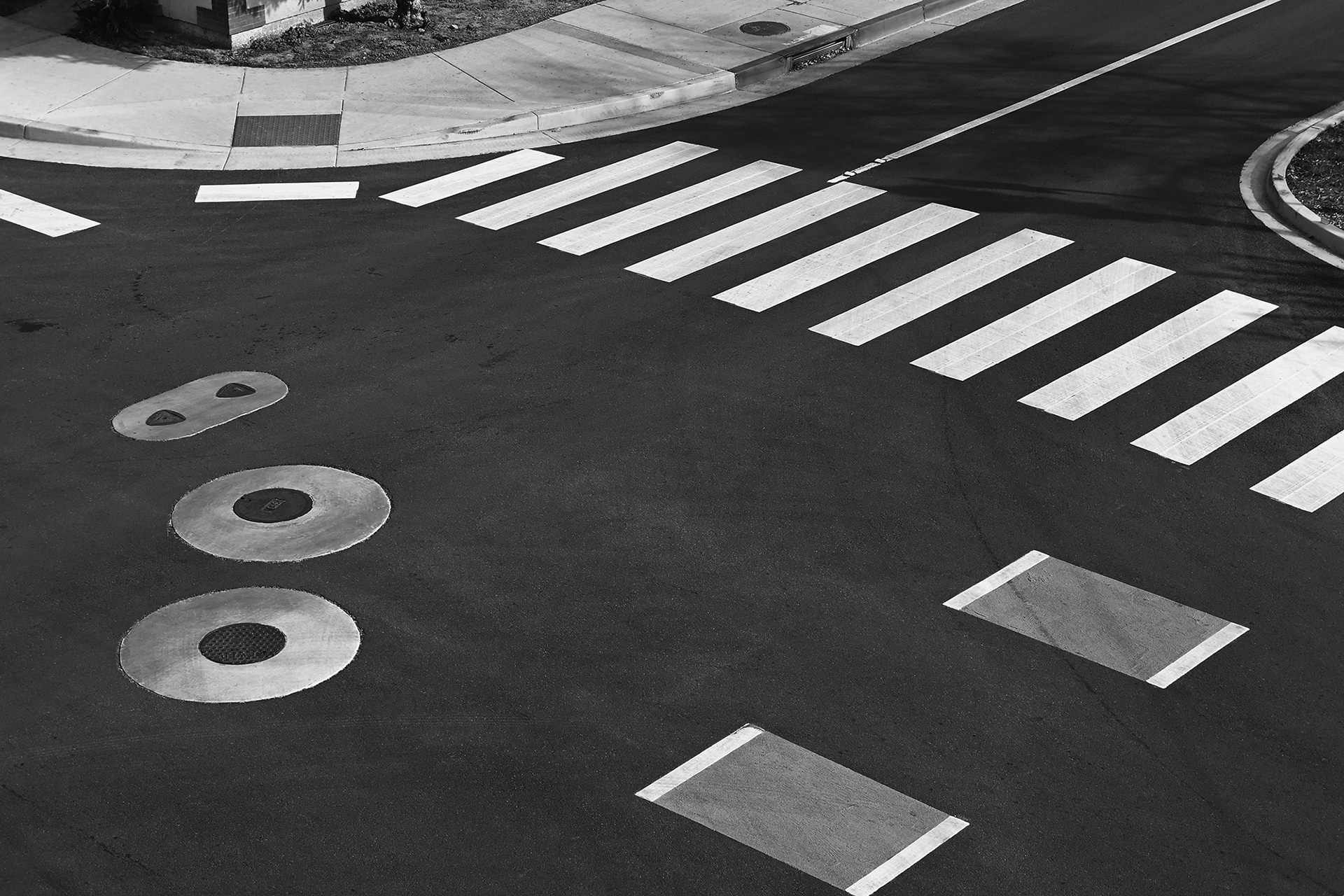 HIgh angle view of an intersection with crosswalk and bike lane markings, black and white photograph