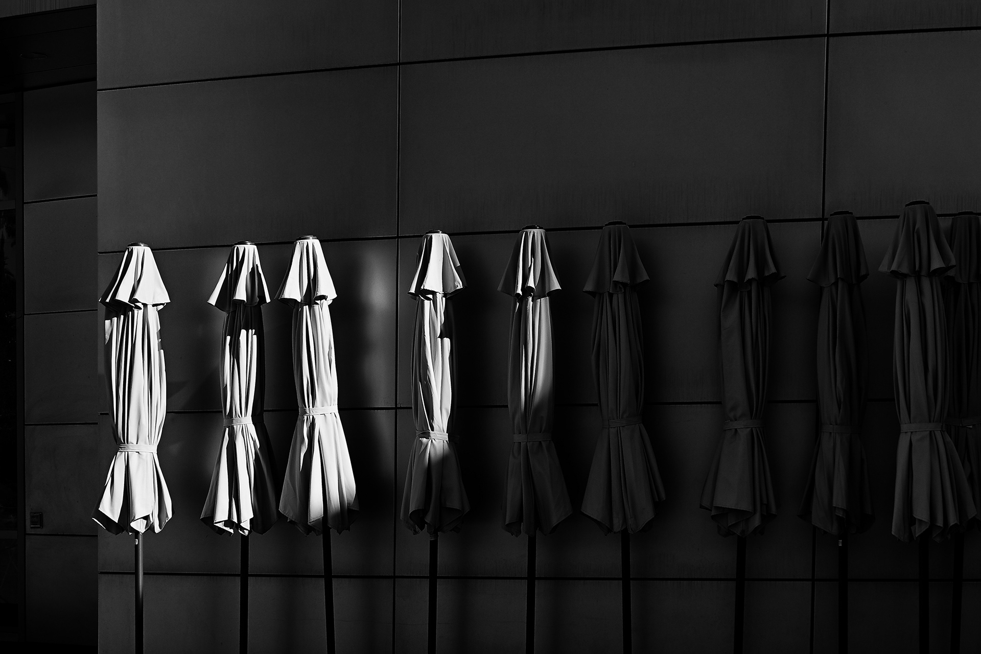 A line of Outdoor Umbrellas in partial sunlight Christ Cathedral, black and white photograph