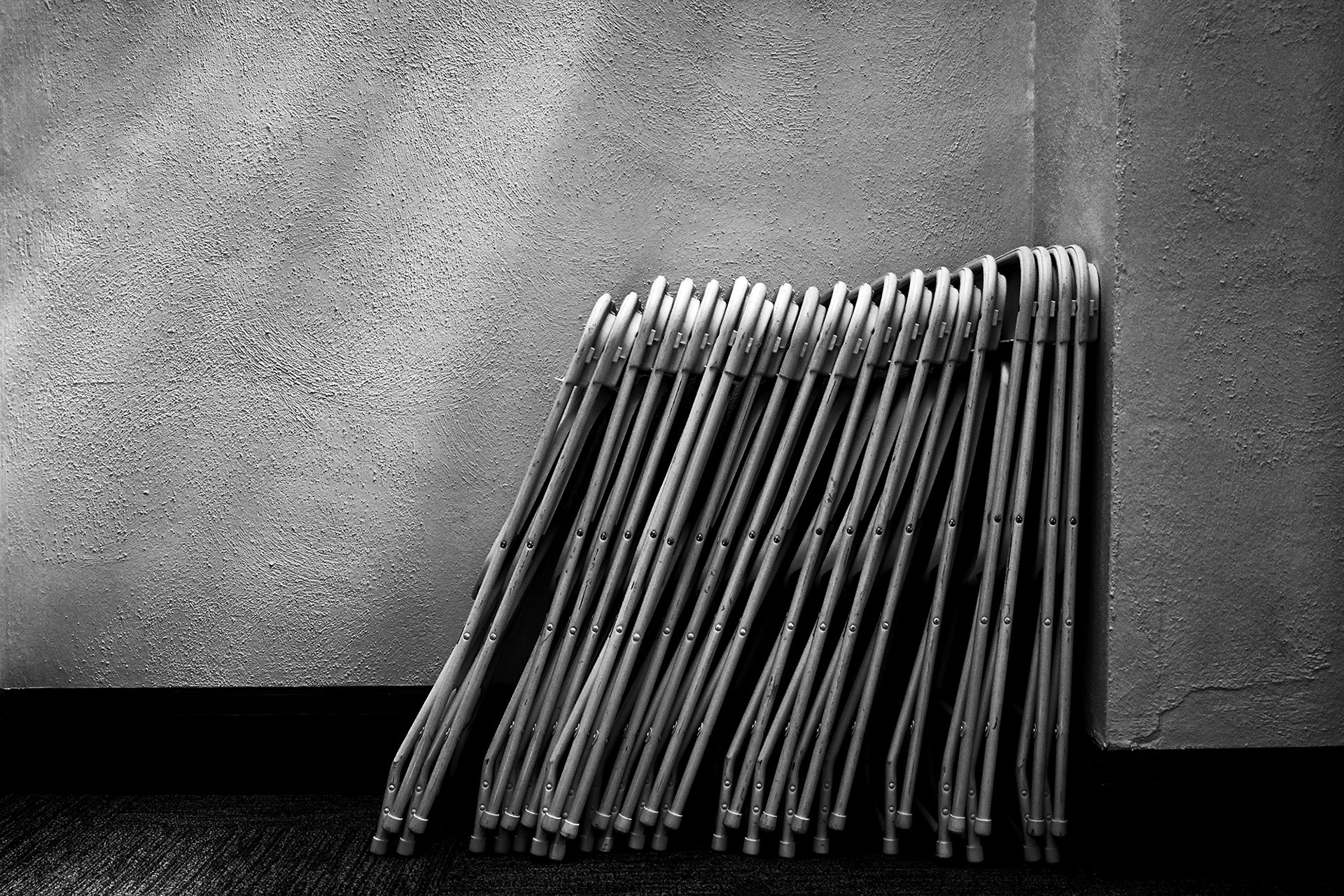 Folding Chairs stacked in a hallway, black and white photograph
