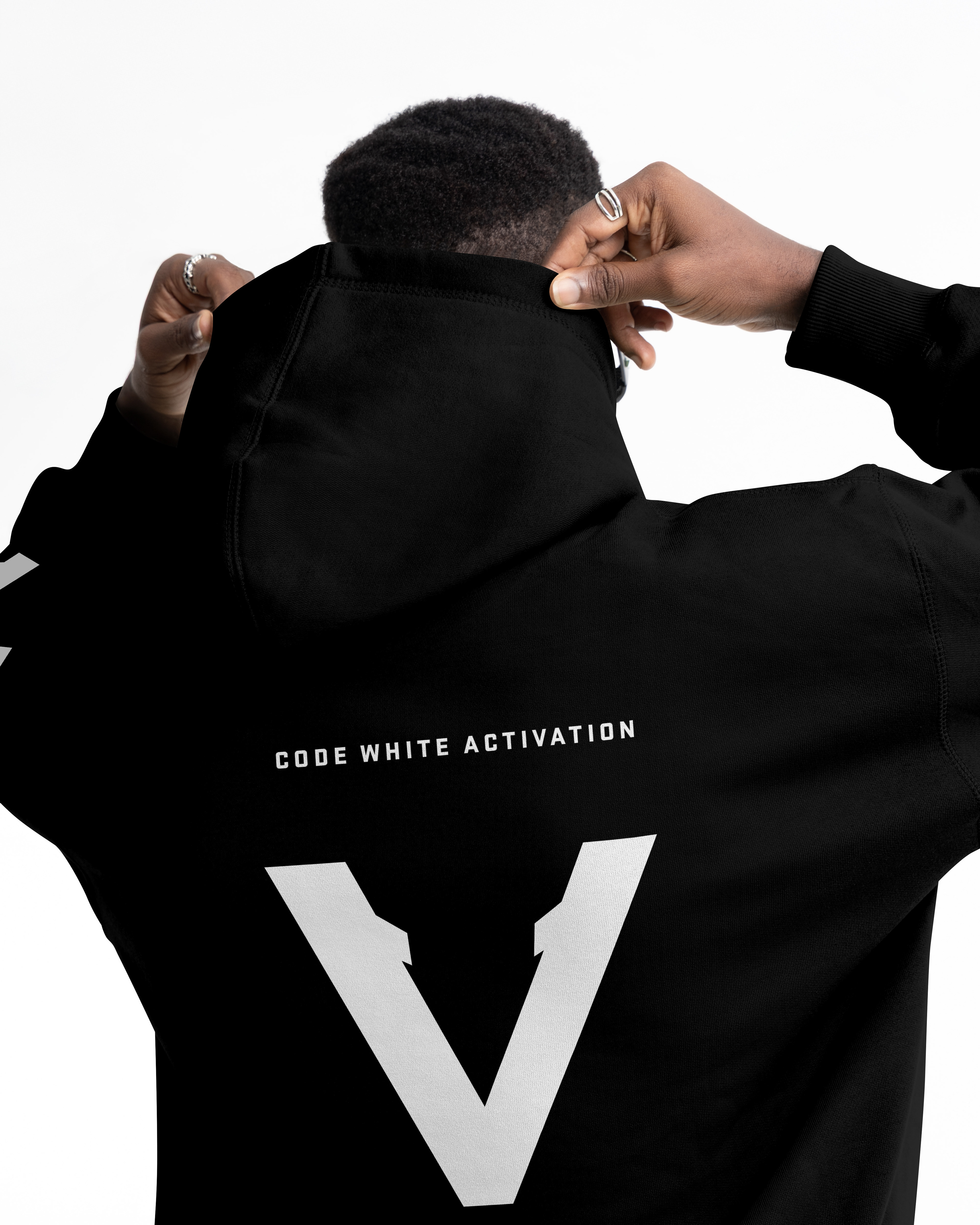 Black Vinciani Code White Activation hoodie with large white V back print, premium streetwear design, close-up rear view of model adjusting hoodie.