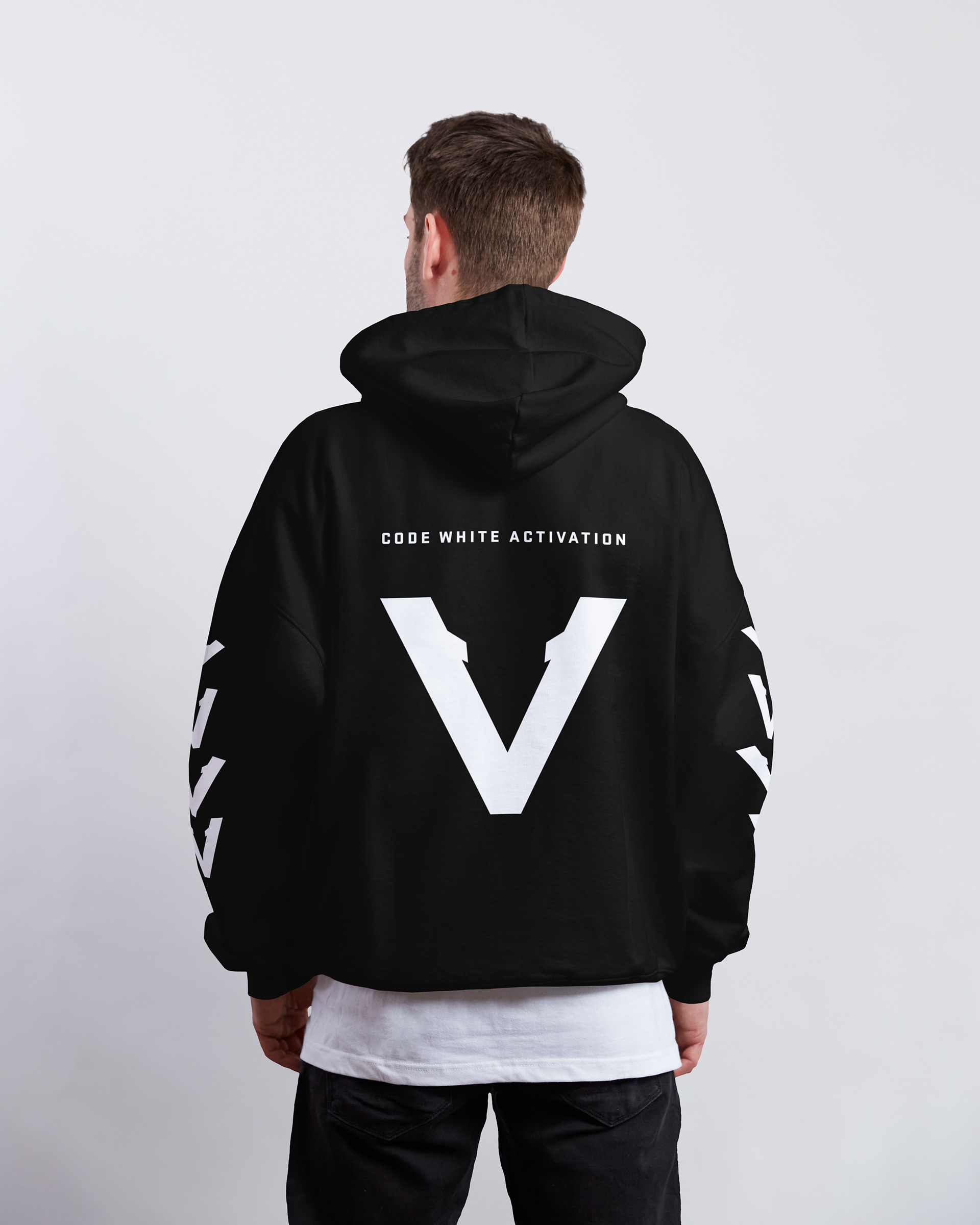 Black Vinciani Code White Activation hoodie with large white V-Mark on the back and sleeve graphics, modern streetwear design shown on male model from rear view.