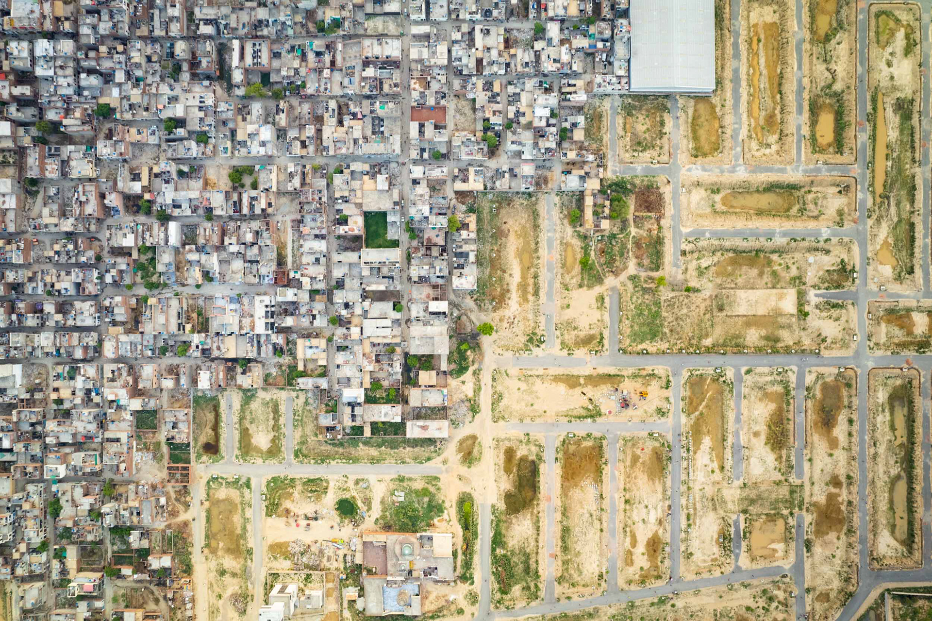 A drone view of a construction site next to a neighborhood.