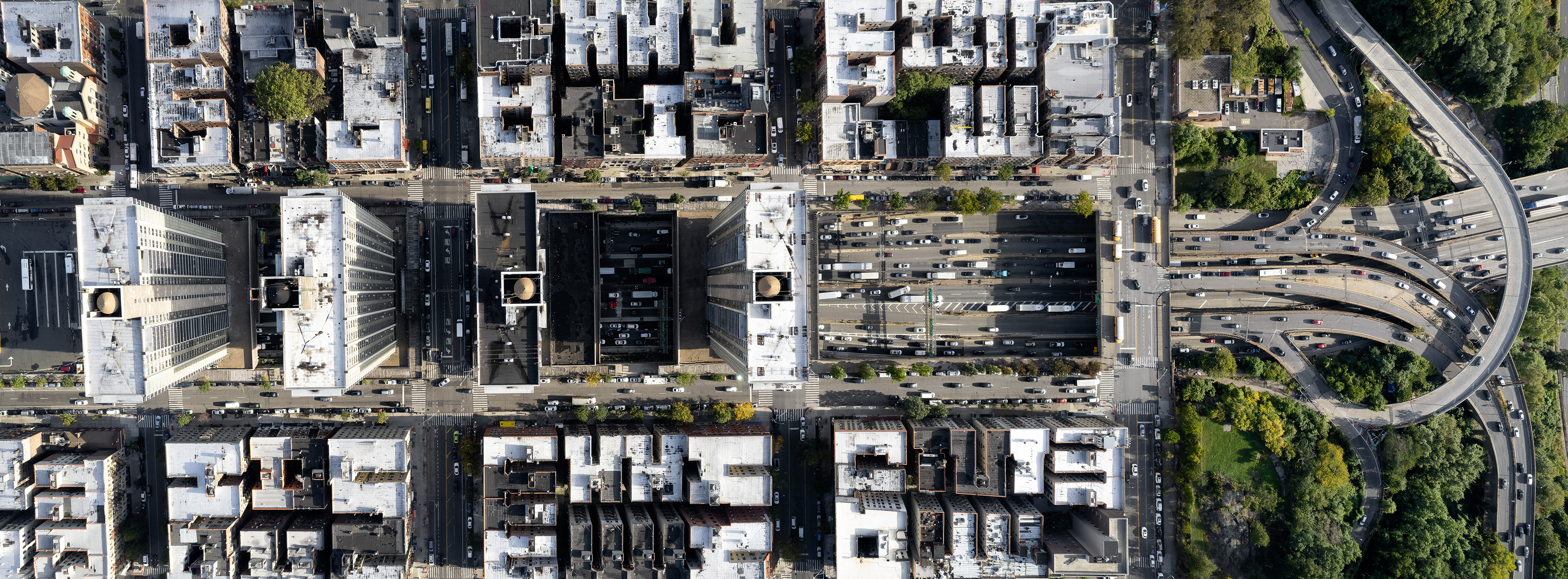 A drone photo of a highway with buildings.