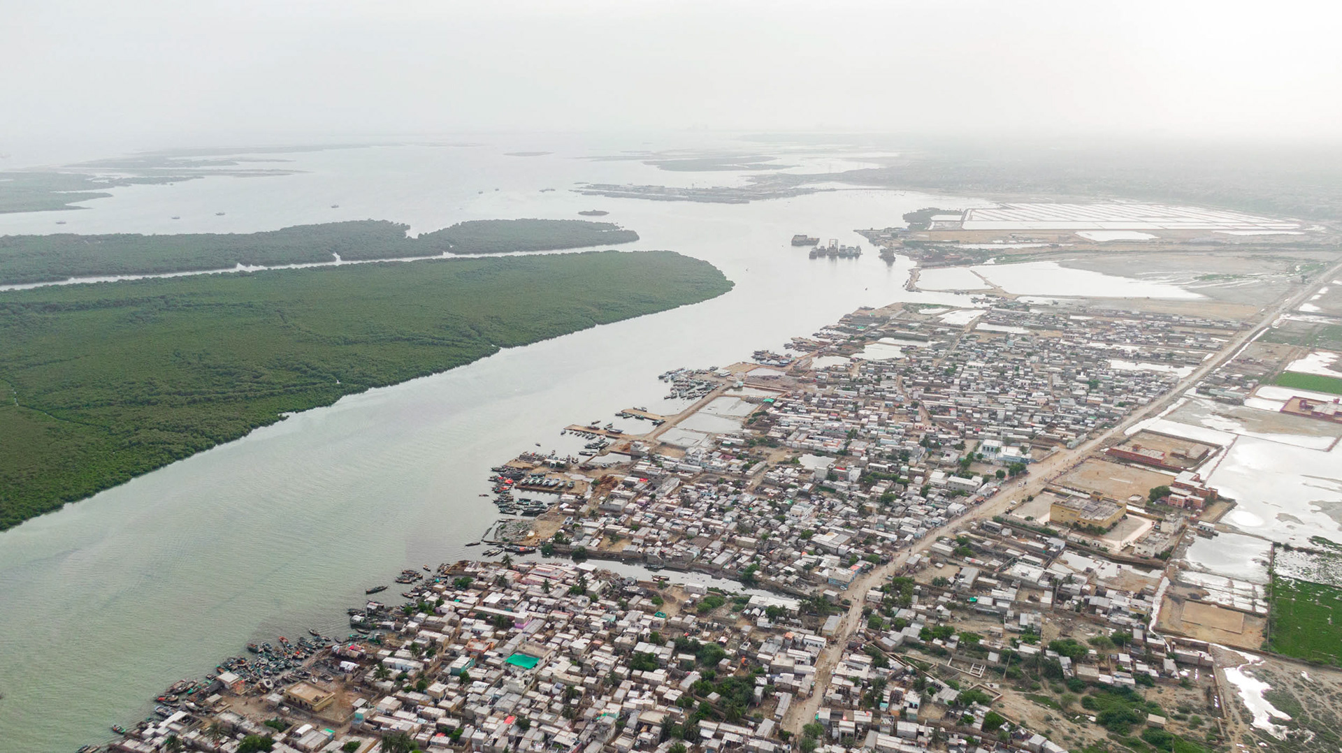 A drone view of a river delta next to buildings.