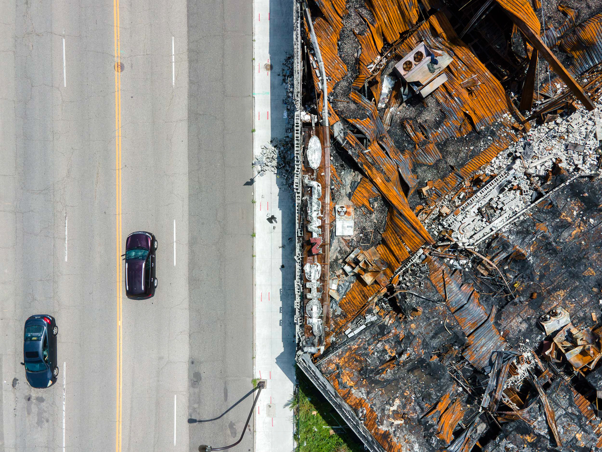 aerial view of cars driving past a destroyed building in minneapolis