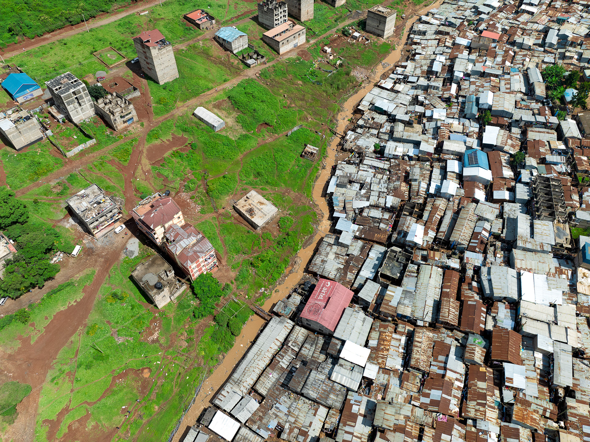 Drone shot showing Nairobi’s urban inequality with well-spaced villas giving way to unplanned settlements.
