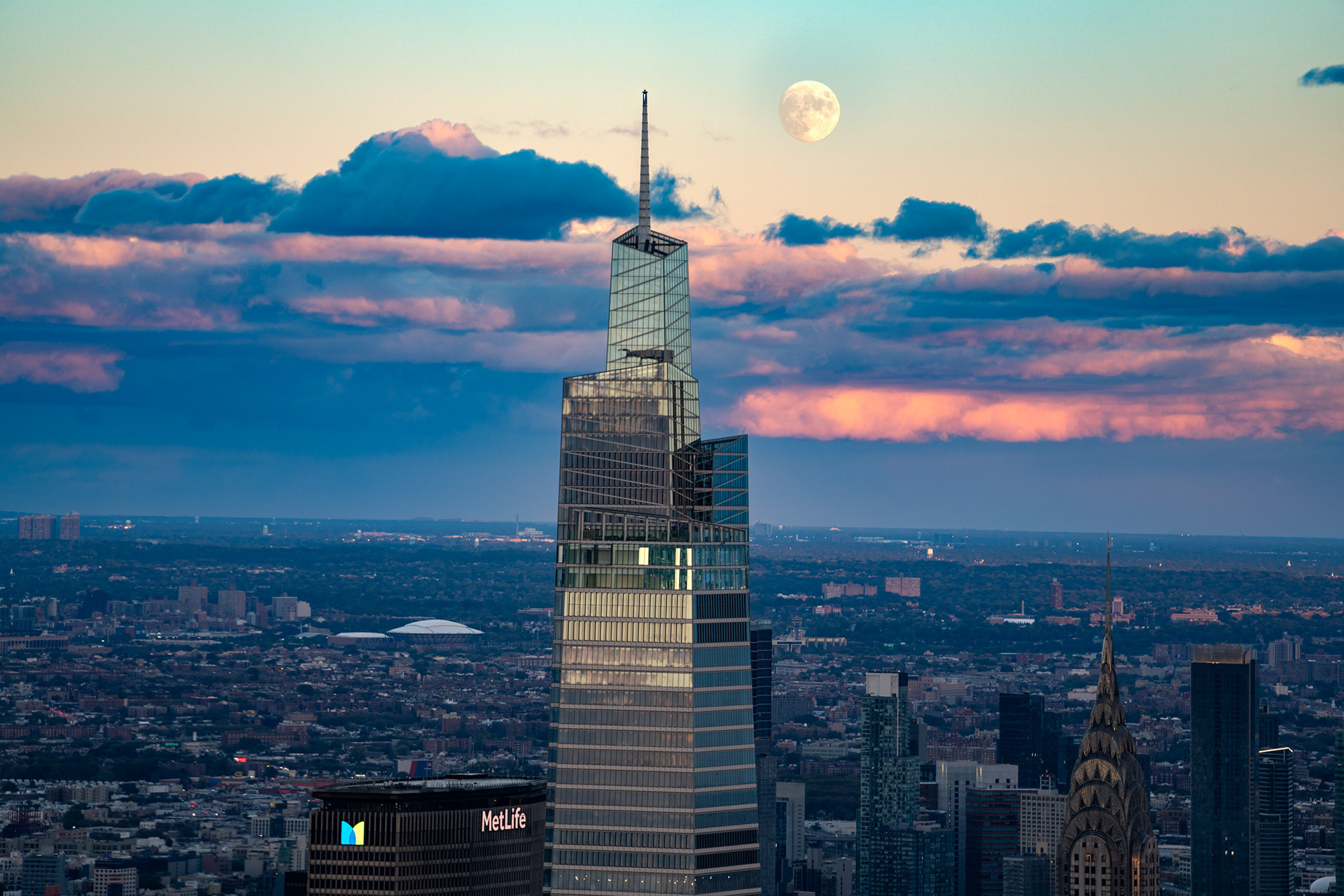 Moon rise over Manhattan, New York City midtown with blue sky and clouds.