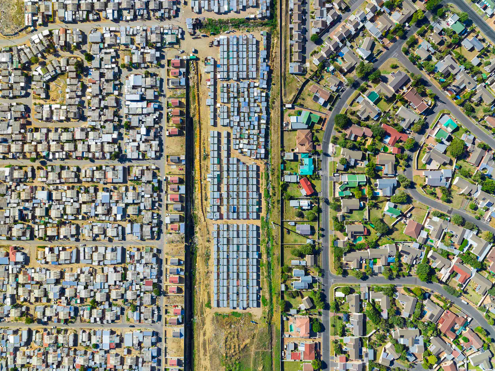 aerial view of shacks next to homes in cape town south africa