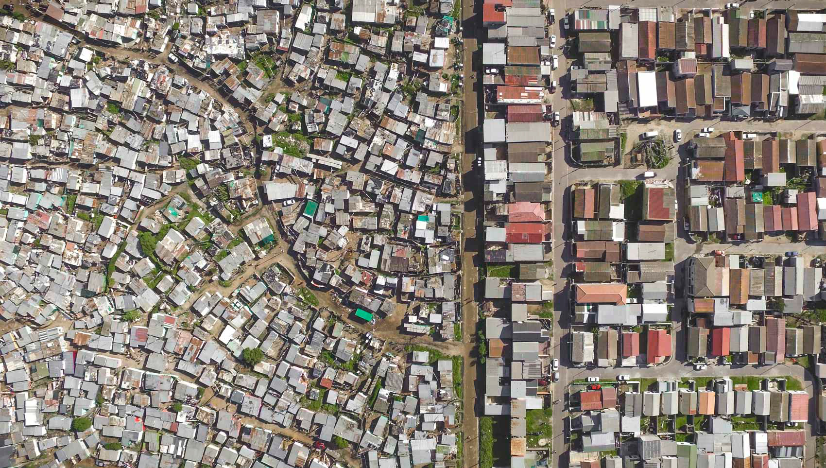 aerial view of shacks next to homes in cape town south africa