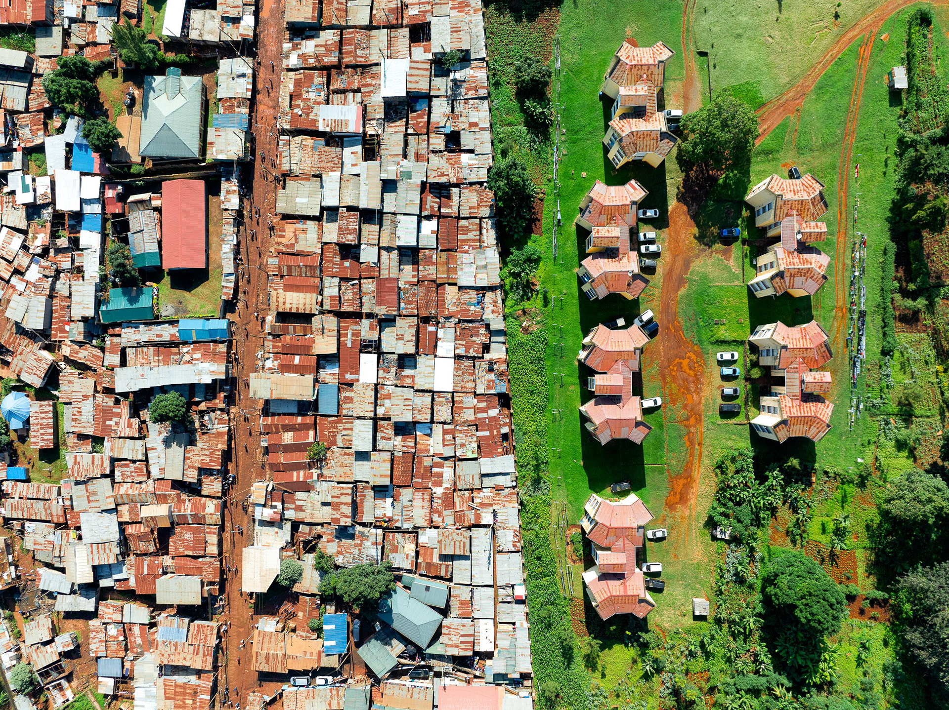 Side-by-side aerial comparison of Kawangare slum and adjacent formal housing in Loresho with red roofs.