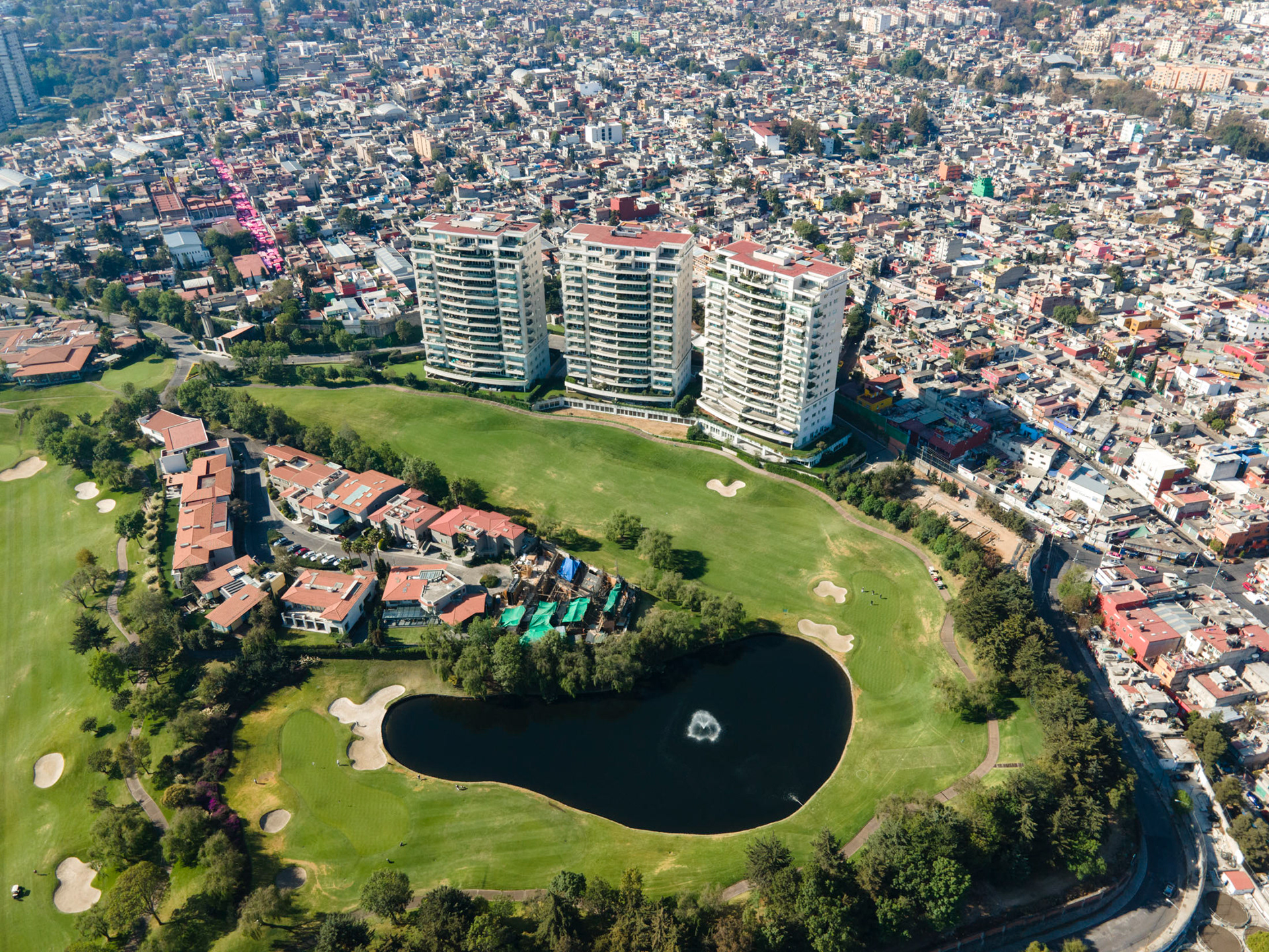 golf course with rich homes next to slums in mexico city