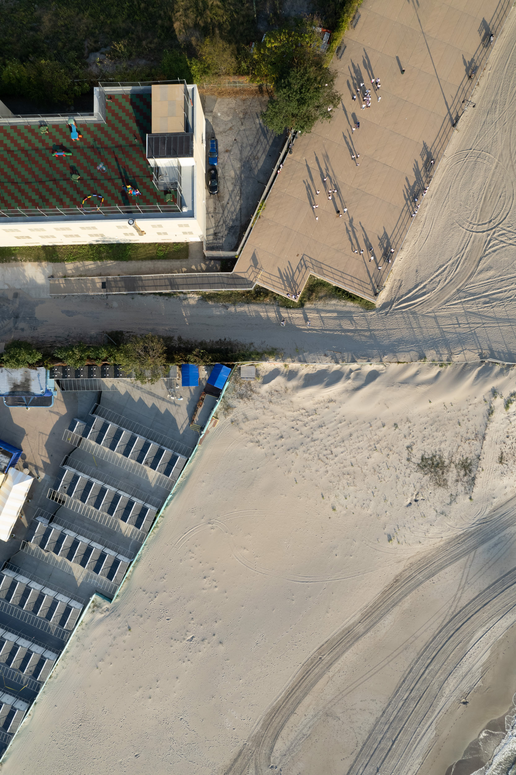 A drone photo of a beach with a fence bisecting it.