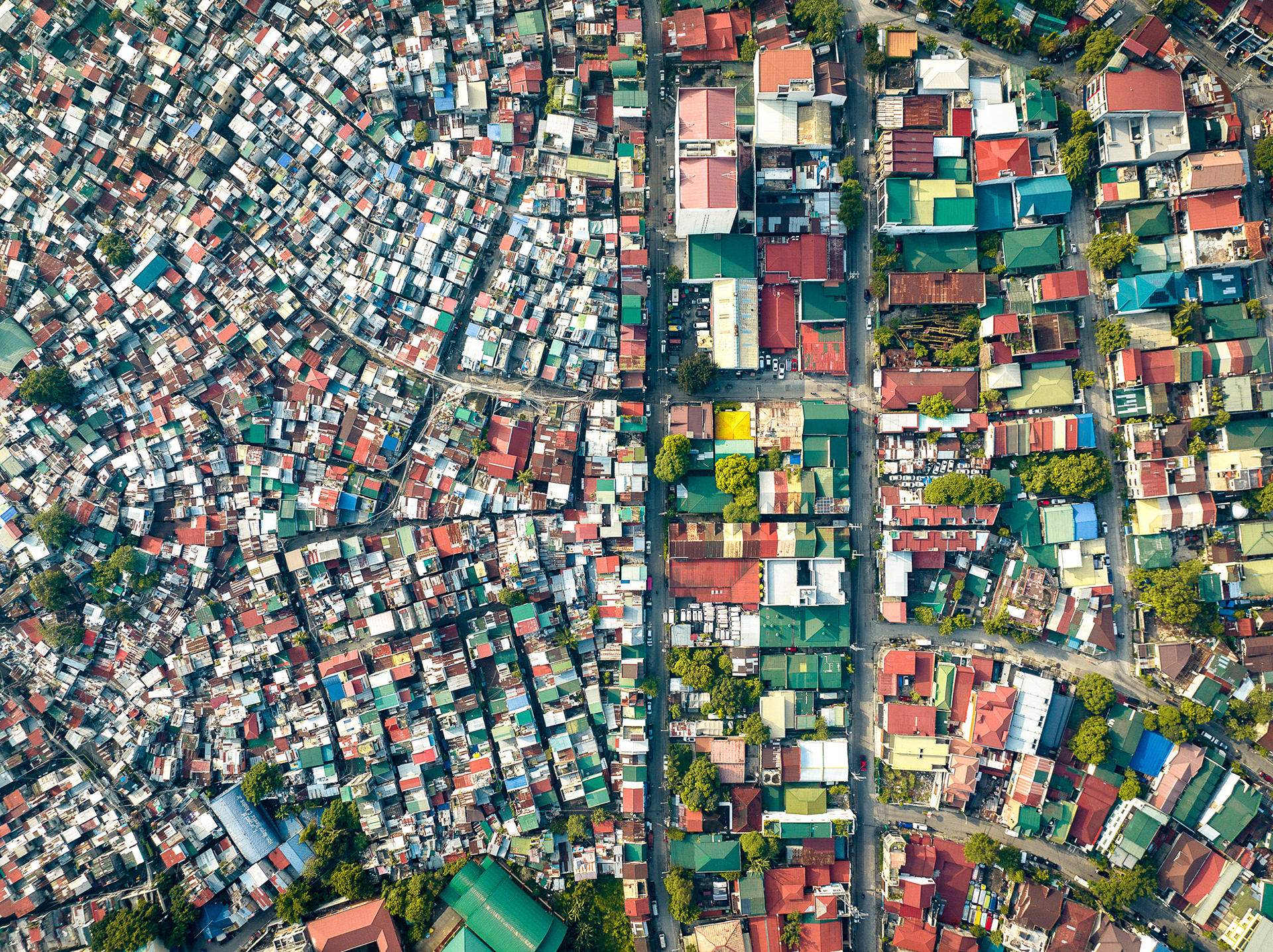 Aerial image of Mandaluyong, Manila, showing a sharp divide between dense slums and planned housing.