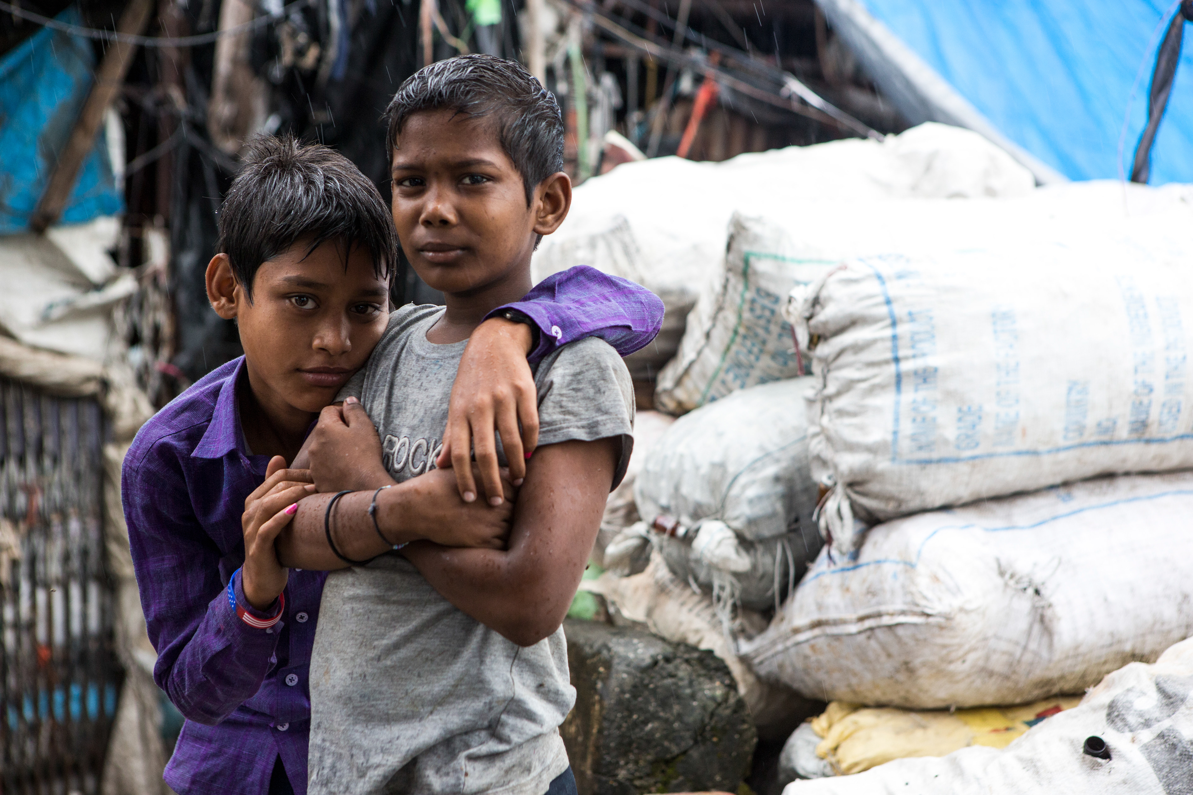 boys in a rainstorm looking at the camera