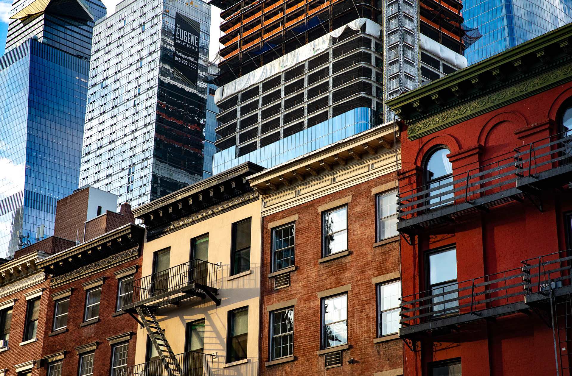 Colorful buildings in an old style with large modern office towers behind them.