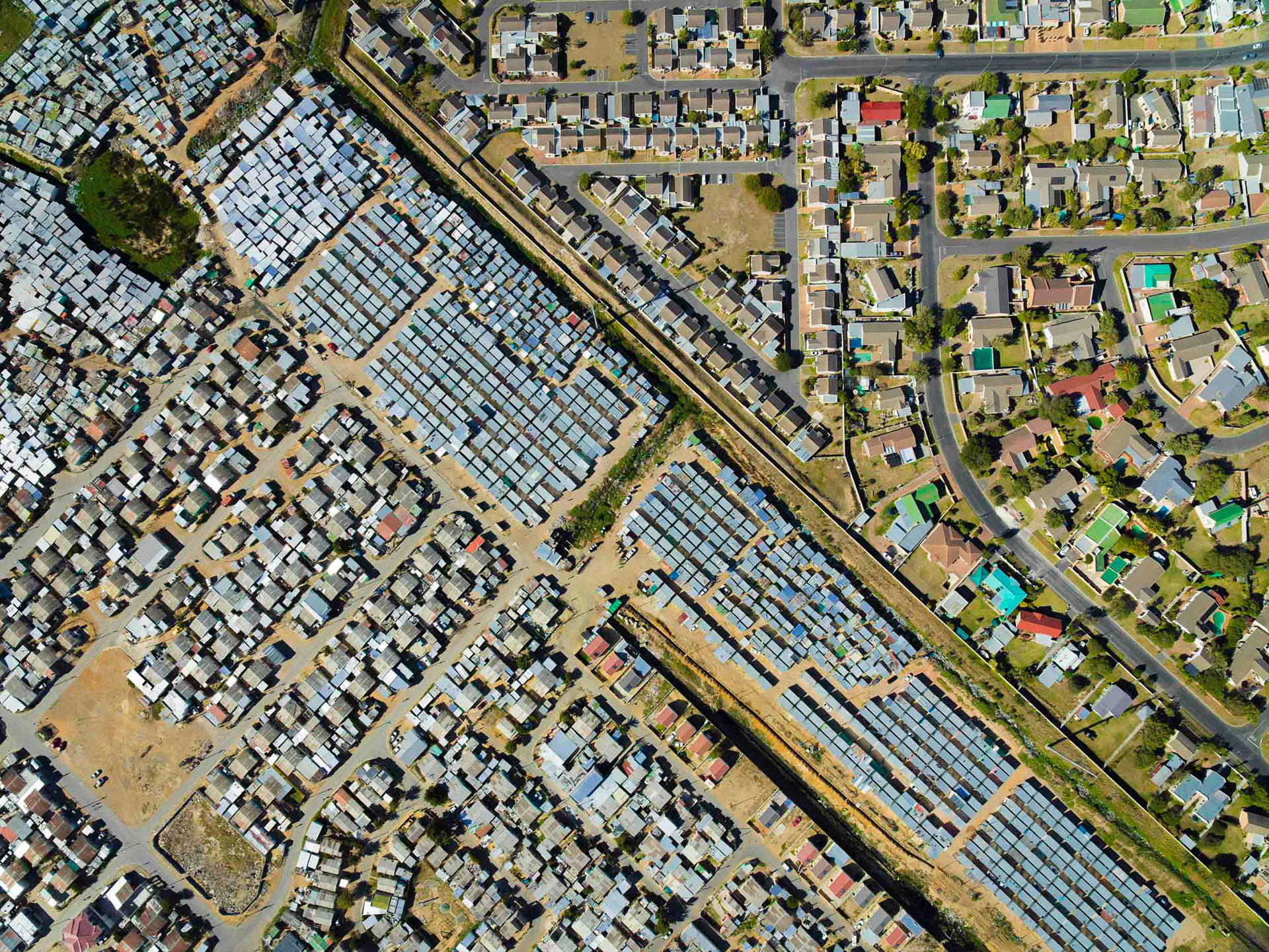 aerial view of shacks next to homes in cape town south africa