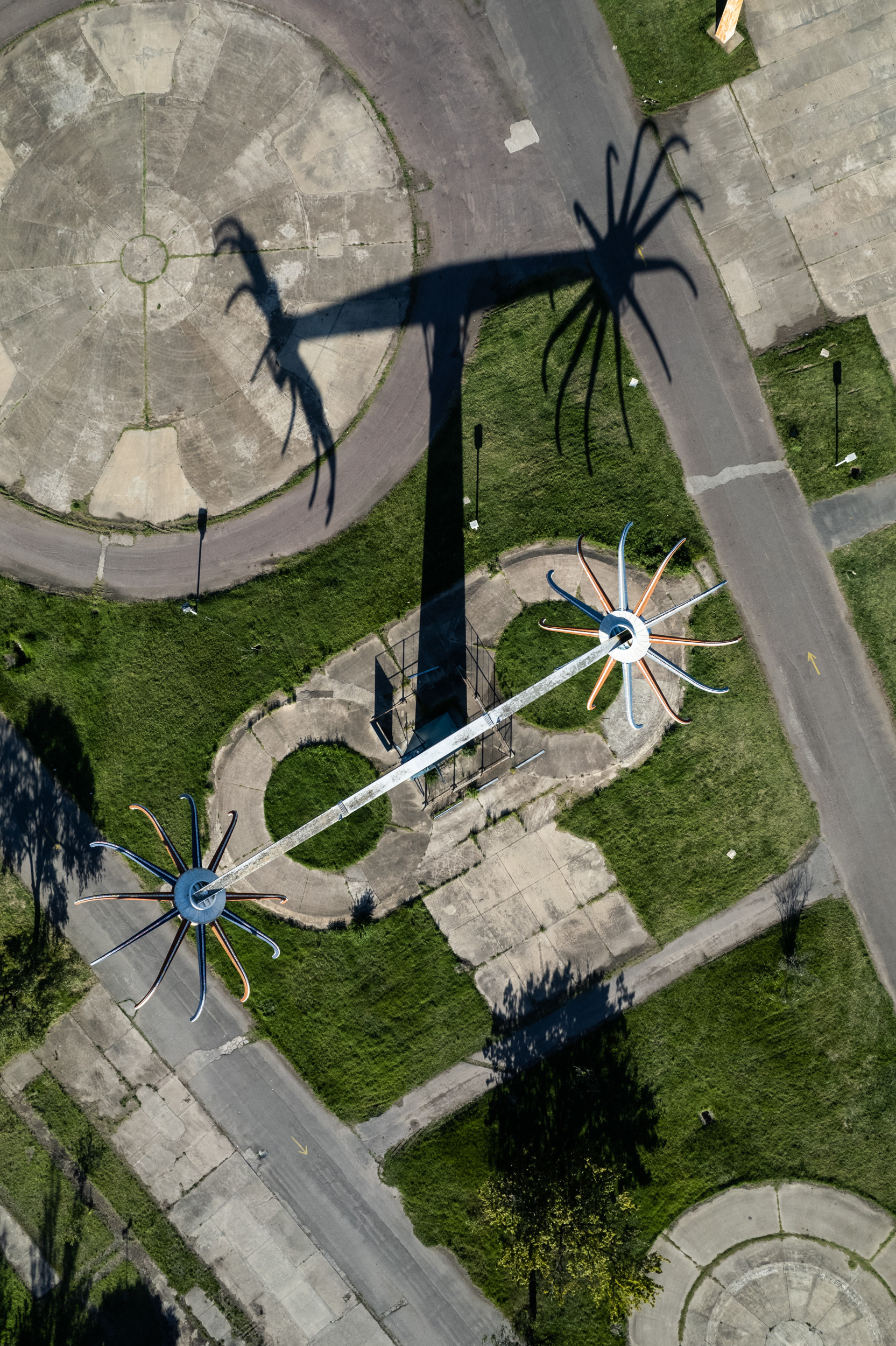 A drone photo of an amusement park ride and a shadow that looks like a spider.