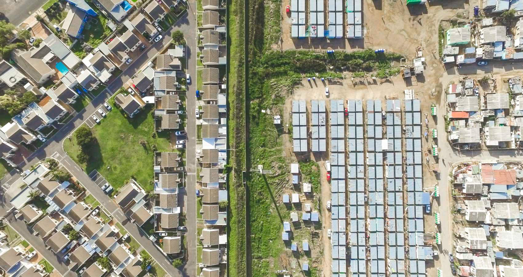 aerial view of shacks next to homes in cape town south africa