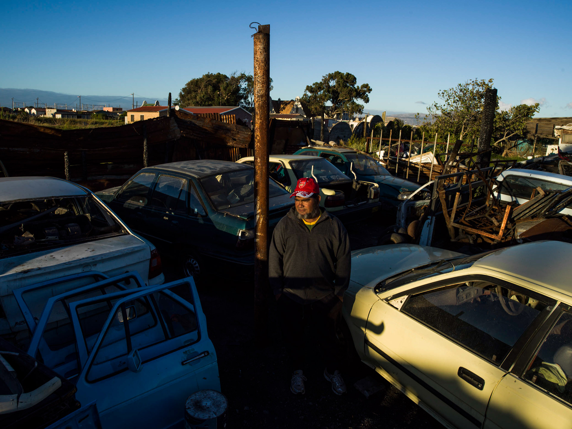 man standing in a junkyard surrounded by cars in cape town south africa