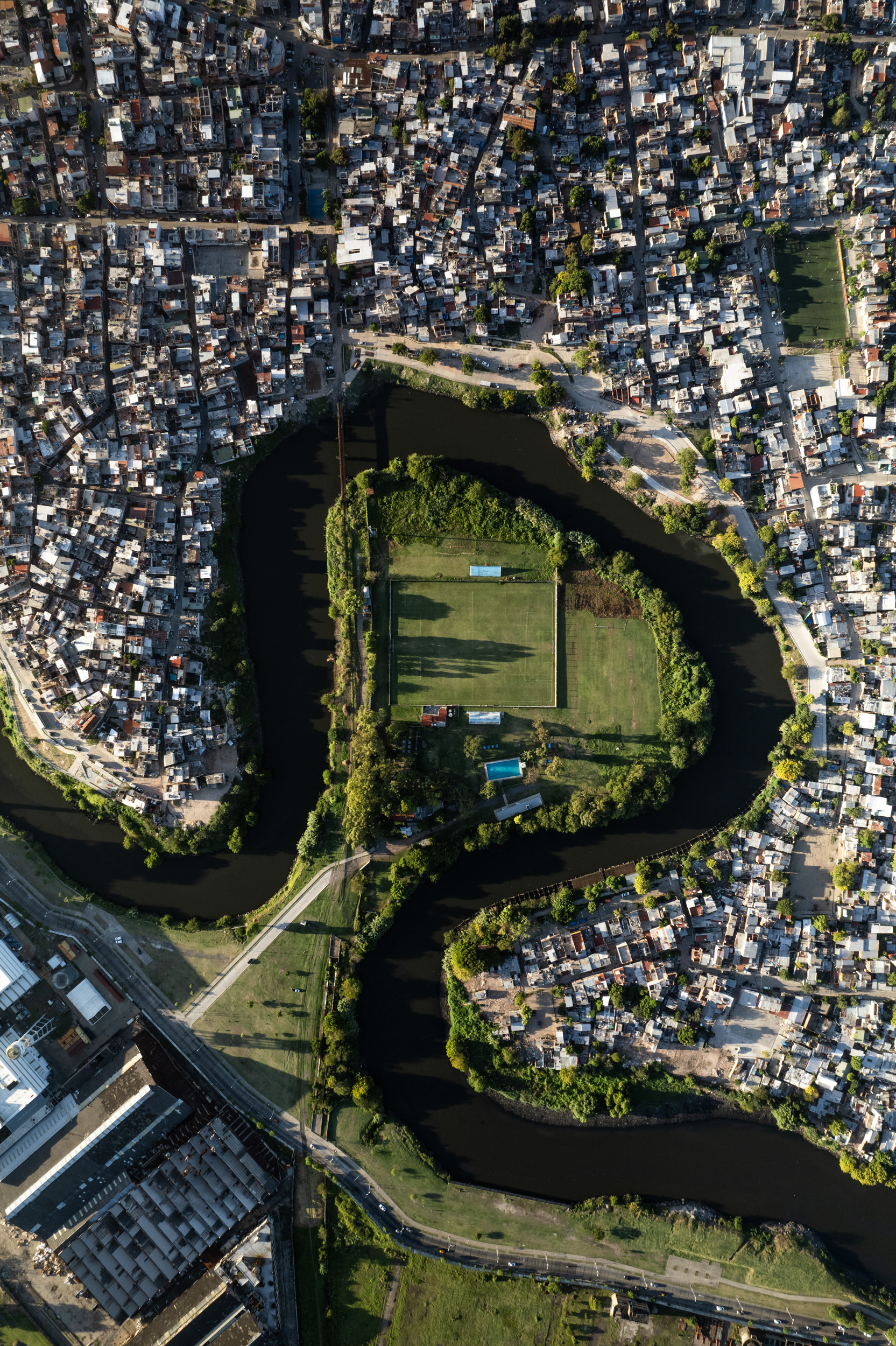 A drone photo of a slum and a river bend.
