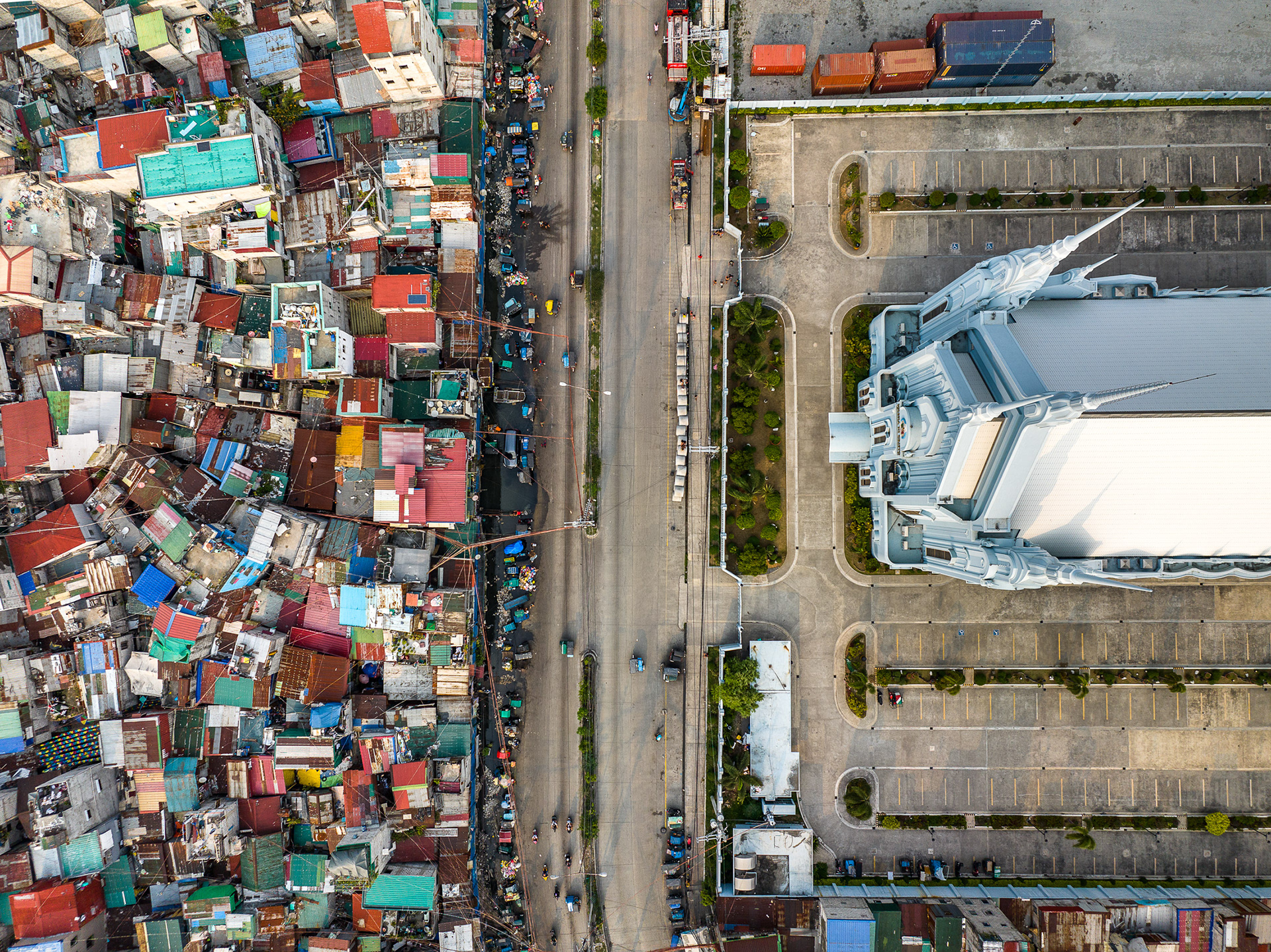 Aerial photo of Iglesia ni Cristo in Manila beside tightly packed informal housing, showing stark inequality.