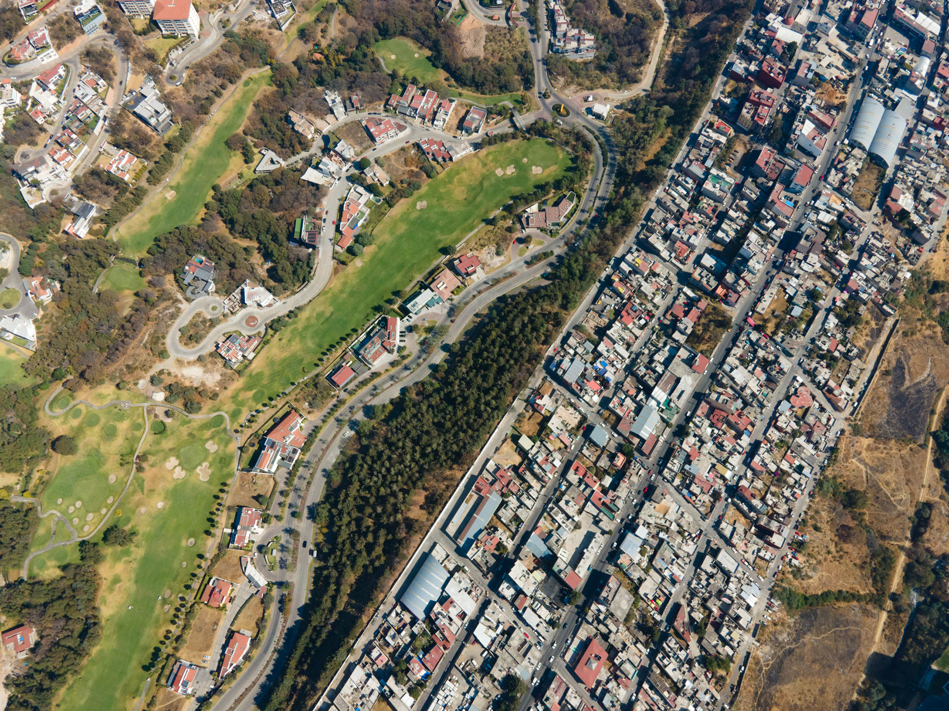 golf course with rich homes next to slums in mexico city