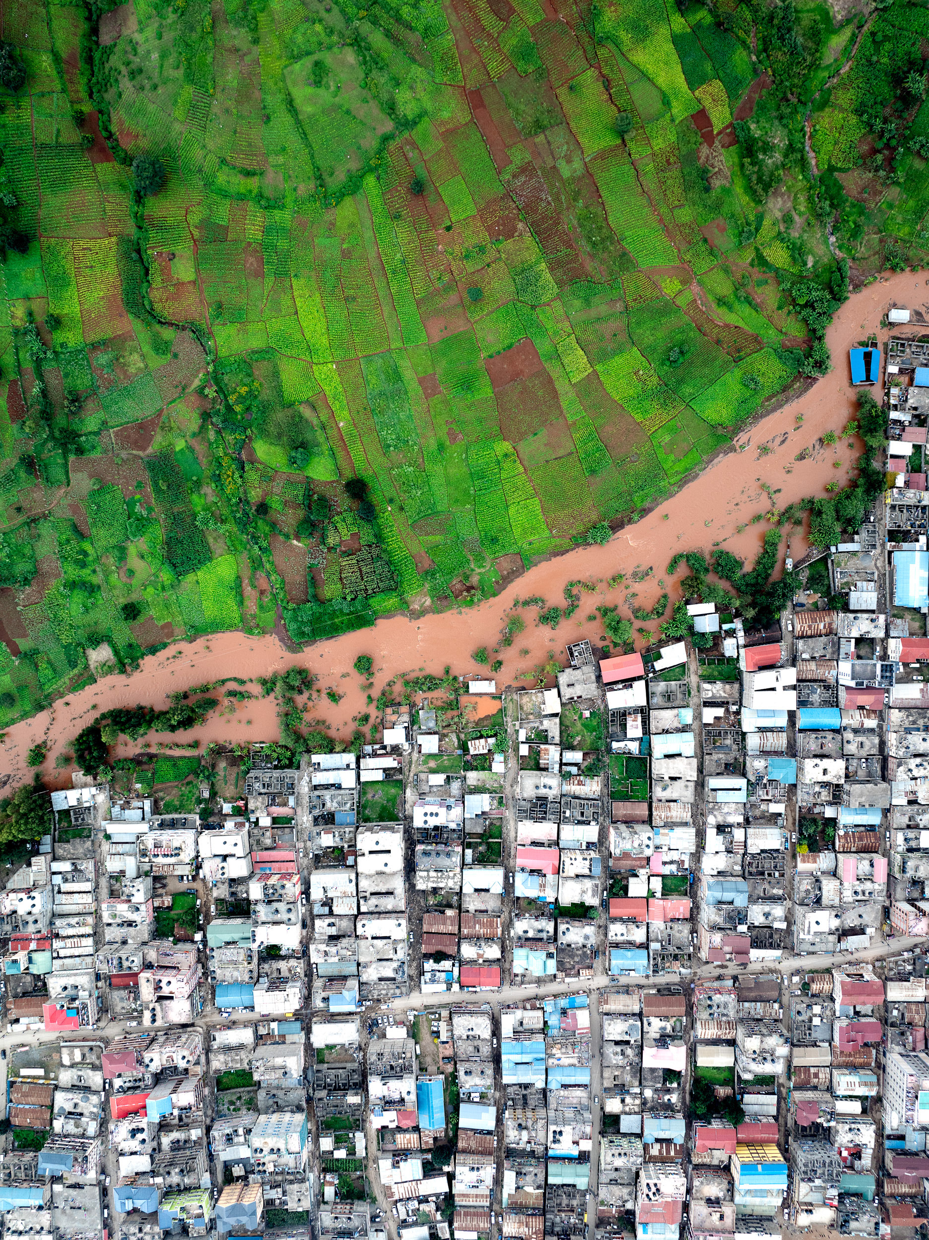 Aerial comparison of Nairobi riverbank slum with industrial runoff and a contrasting greener section upstream.