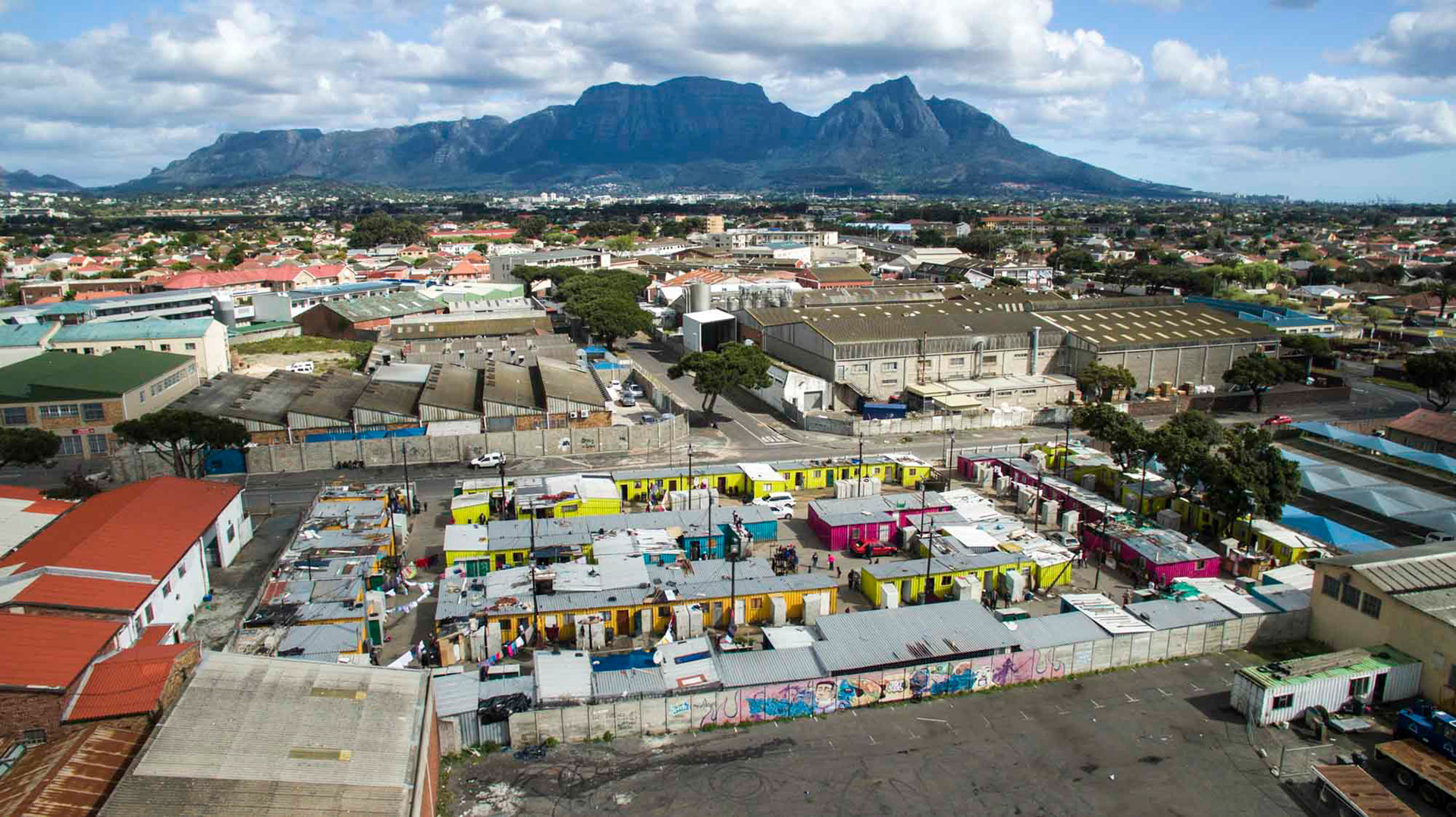 aerial view of shacks with the mountain in the background in cape town