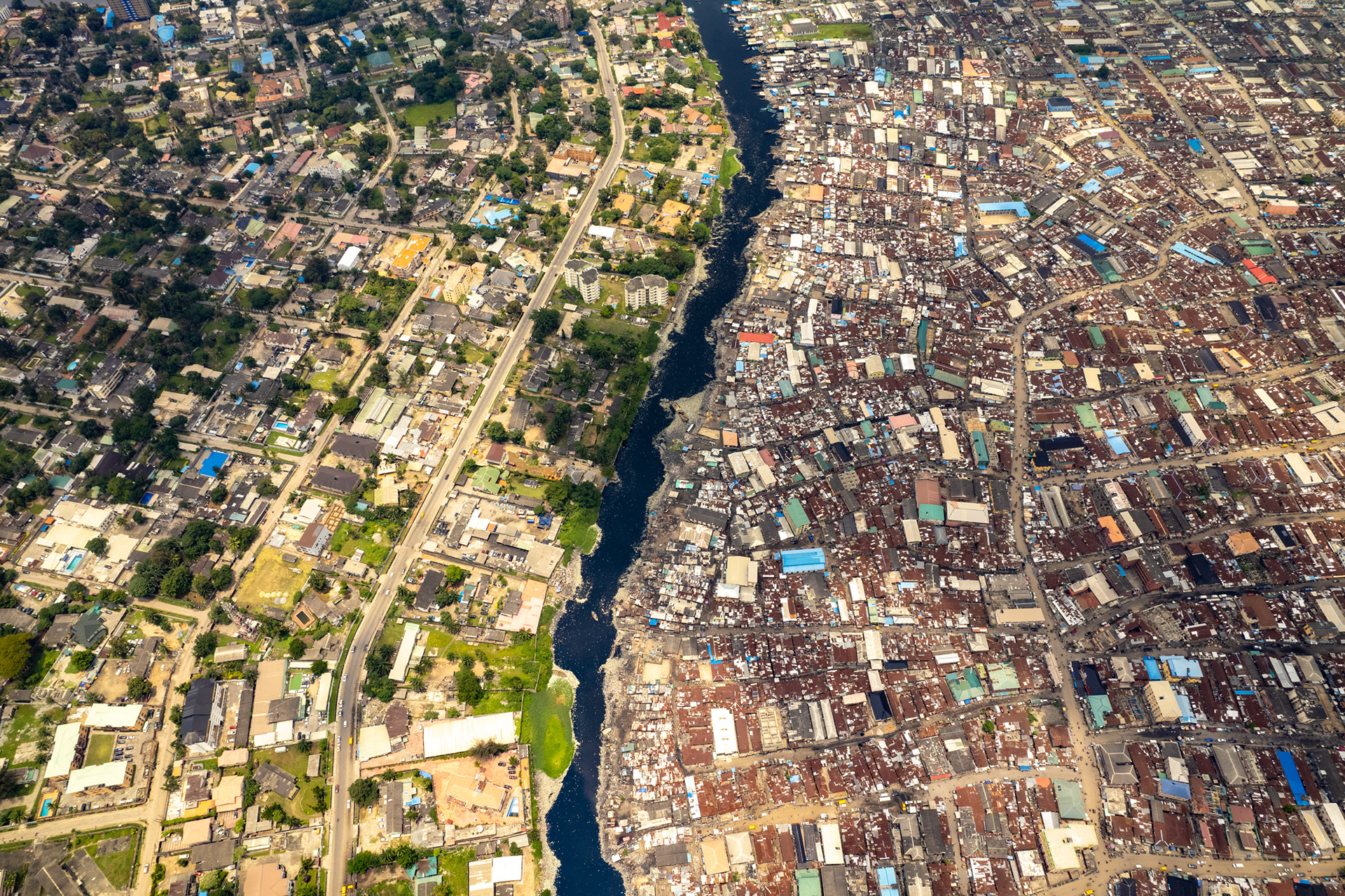 A drone view of a slum in Lagos next to a green middle class community.