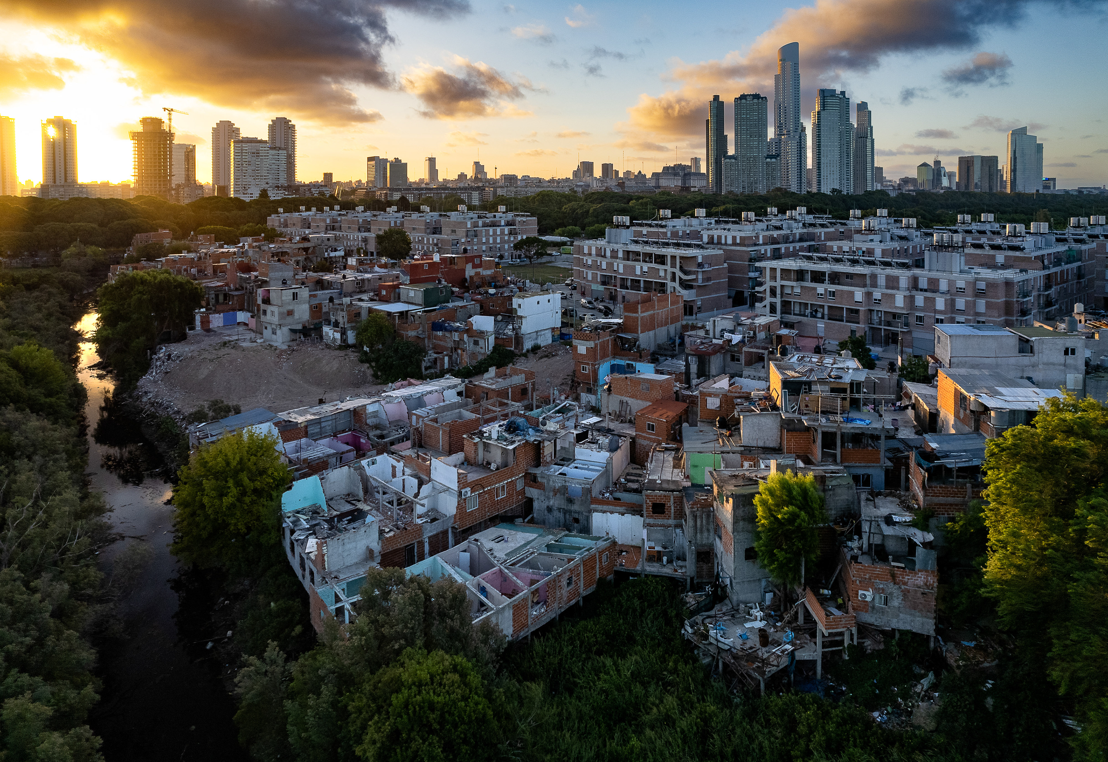 A slum at sunset in front of skyscrapers in Buenos Aires, Argentina.