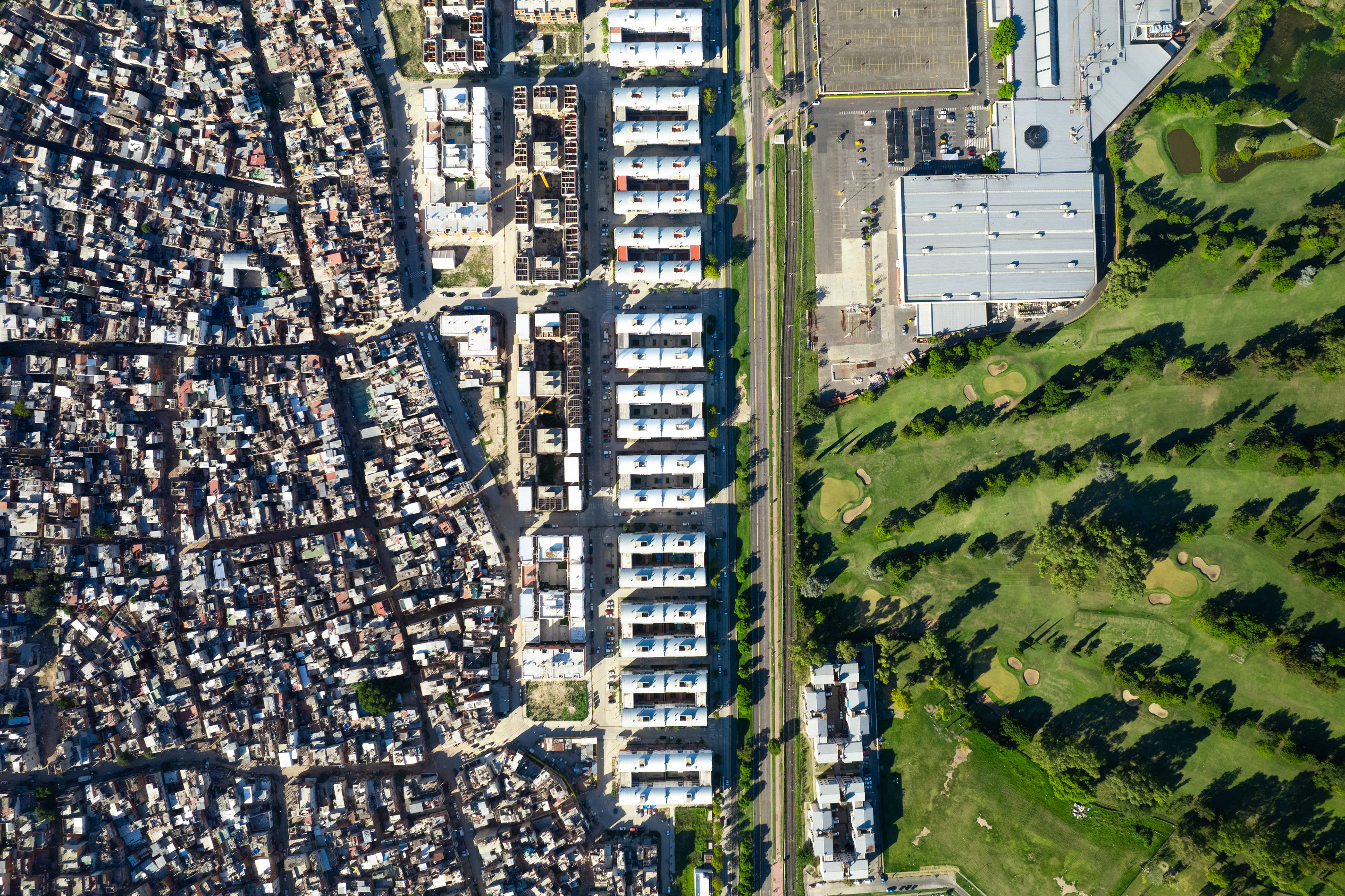 A drone photo of a slum next to a golf course.