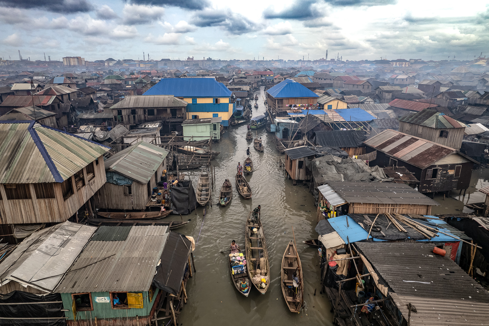 An aerial view of canoes in a slum, with cloudy weather.