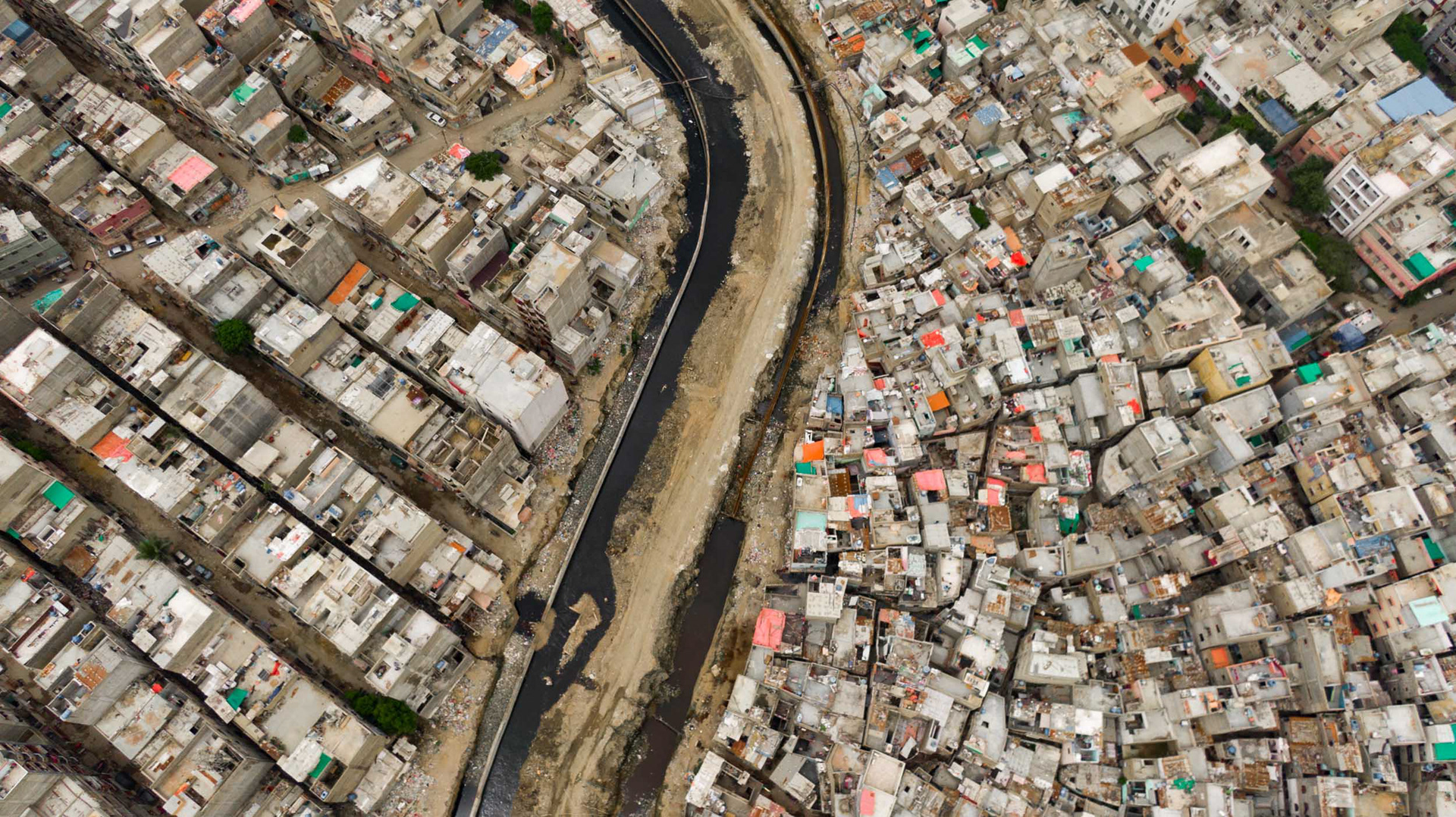 A drone view of two communities bisected by a river.