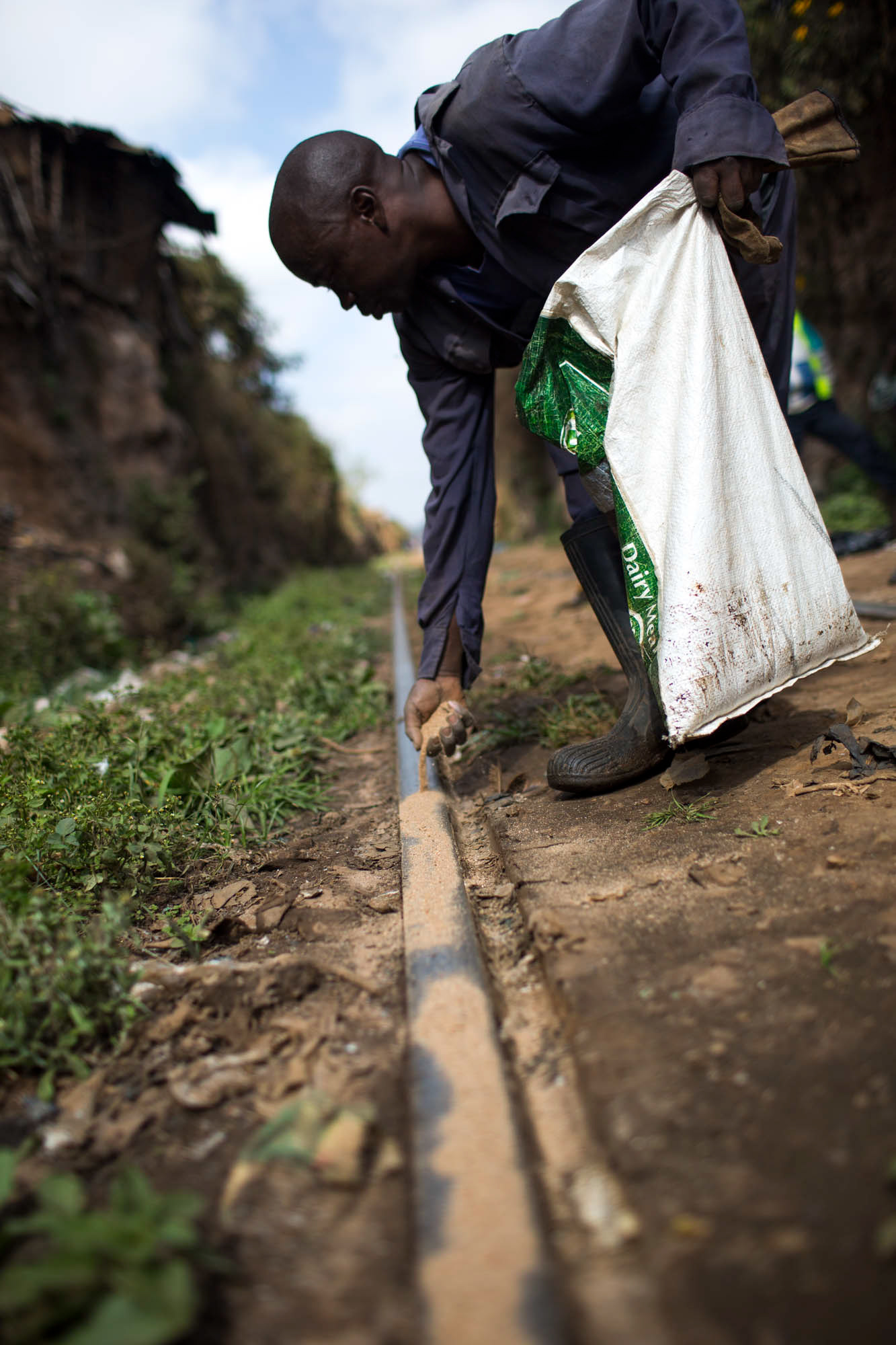 man putting sand on train tracks in nairobi