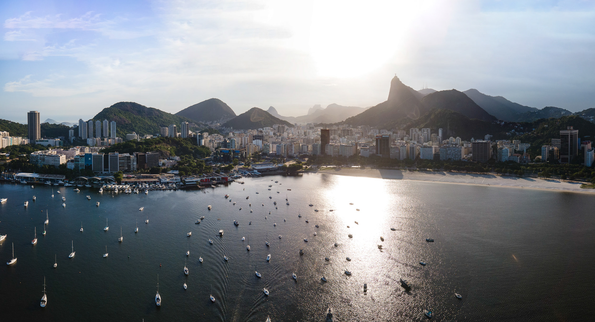 Aerial photo of Guanabara Bay at sunset, facing Botafogo with Christ the Redeemer atop Corcovado mountain in the distance.