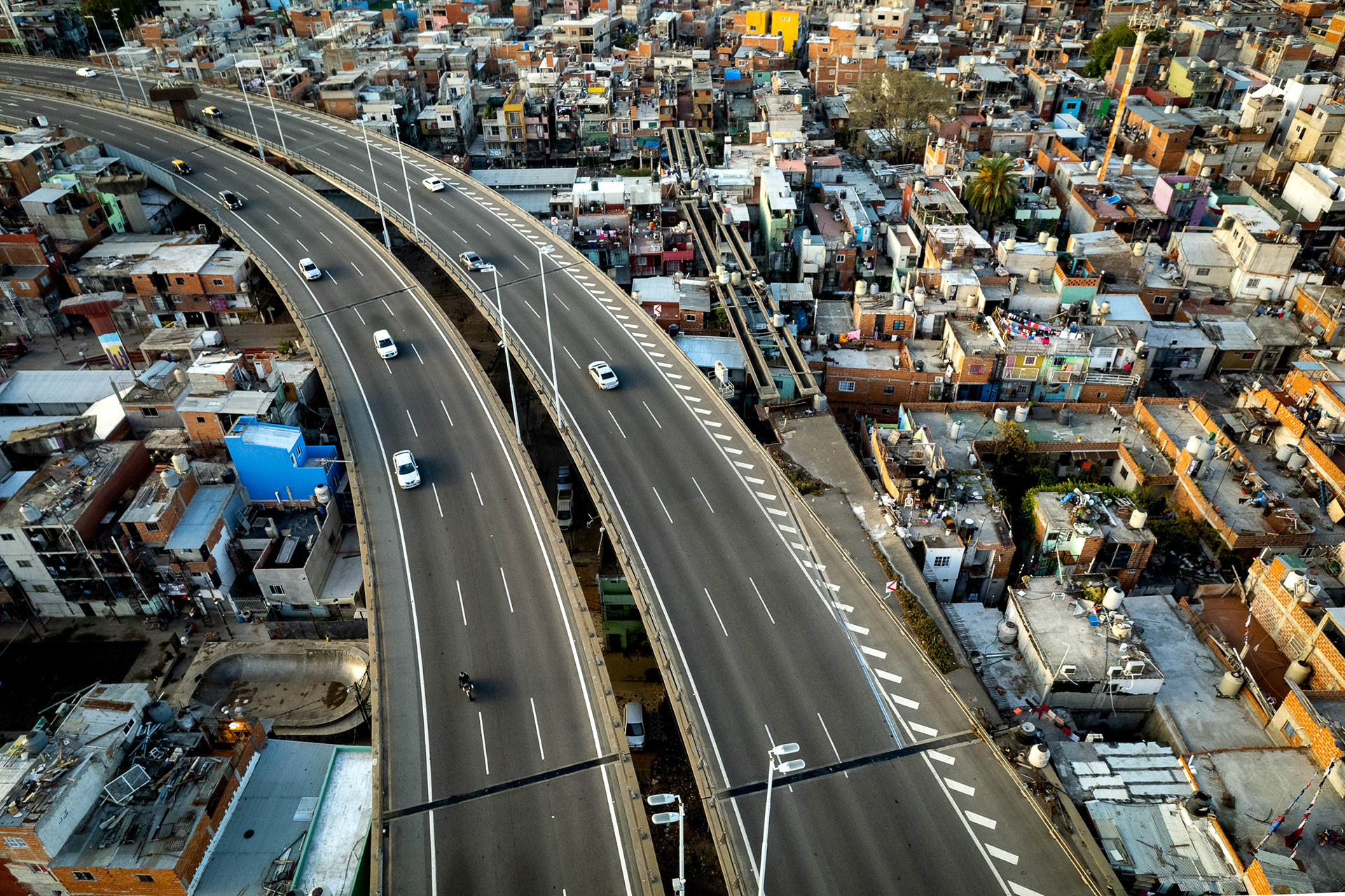 A drone photo of a highway over a slum.