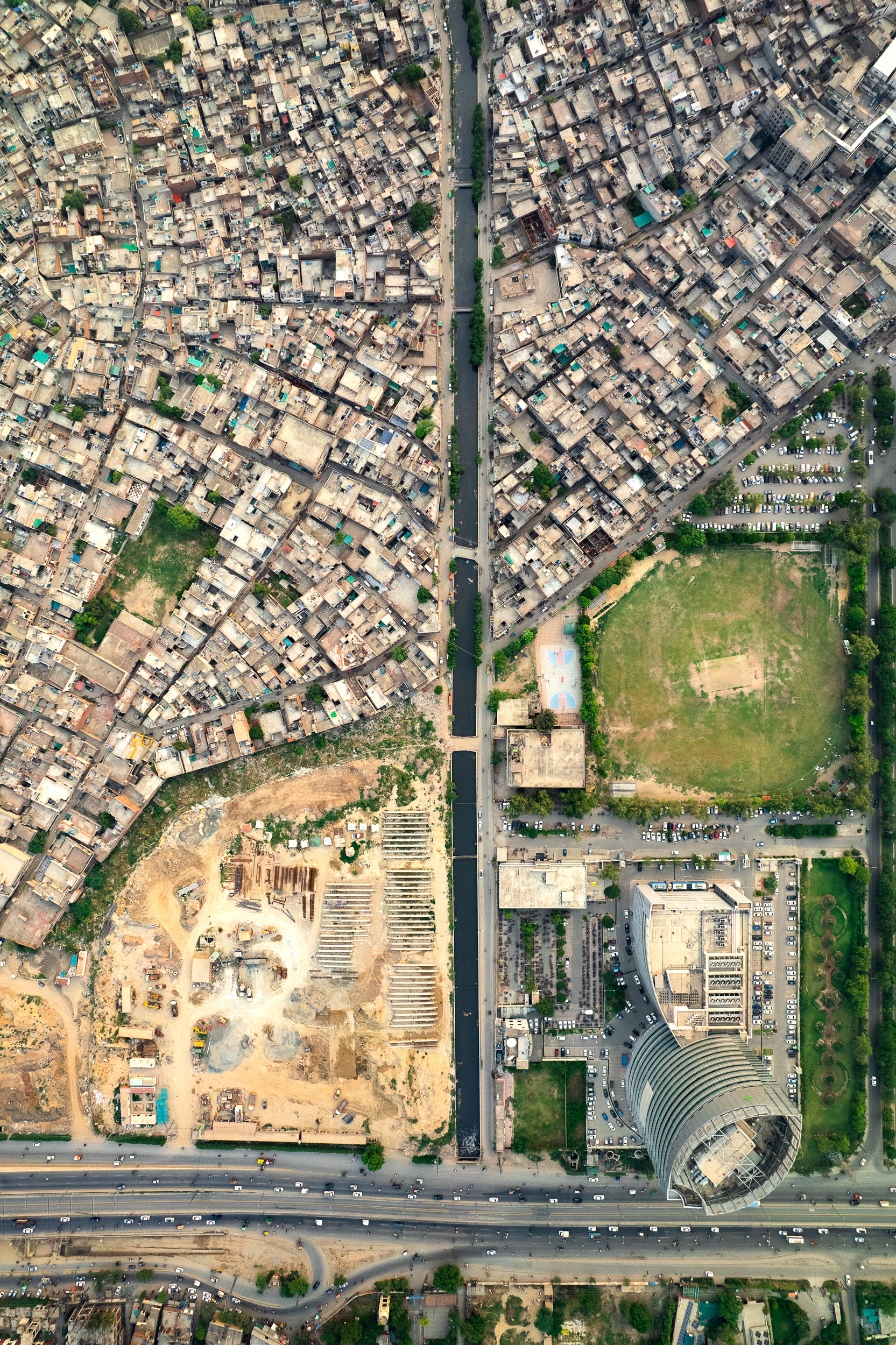 A drone view of a slum next to a highway.