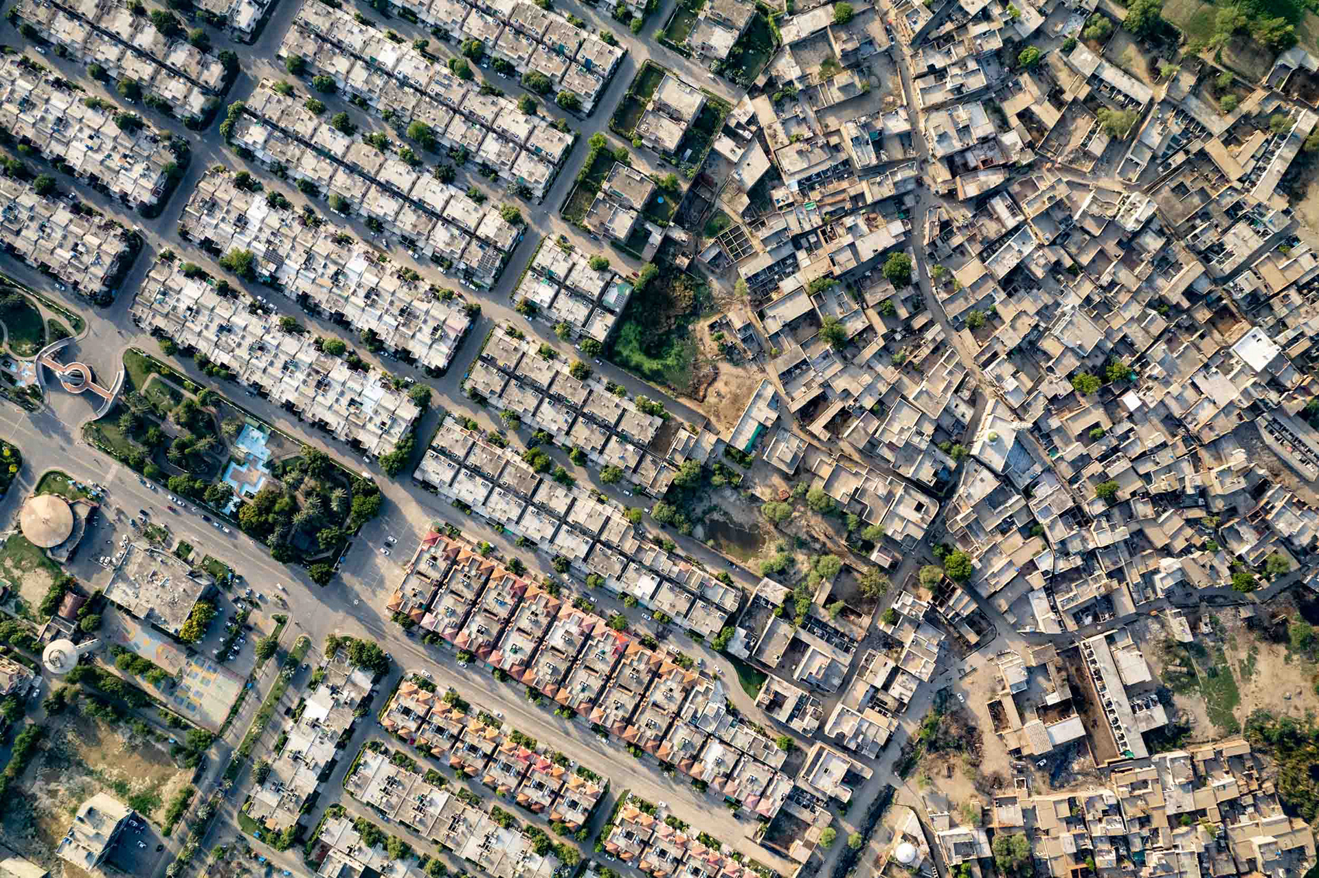 A drone view of a jumbled neighborhood next to an orderly one.