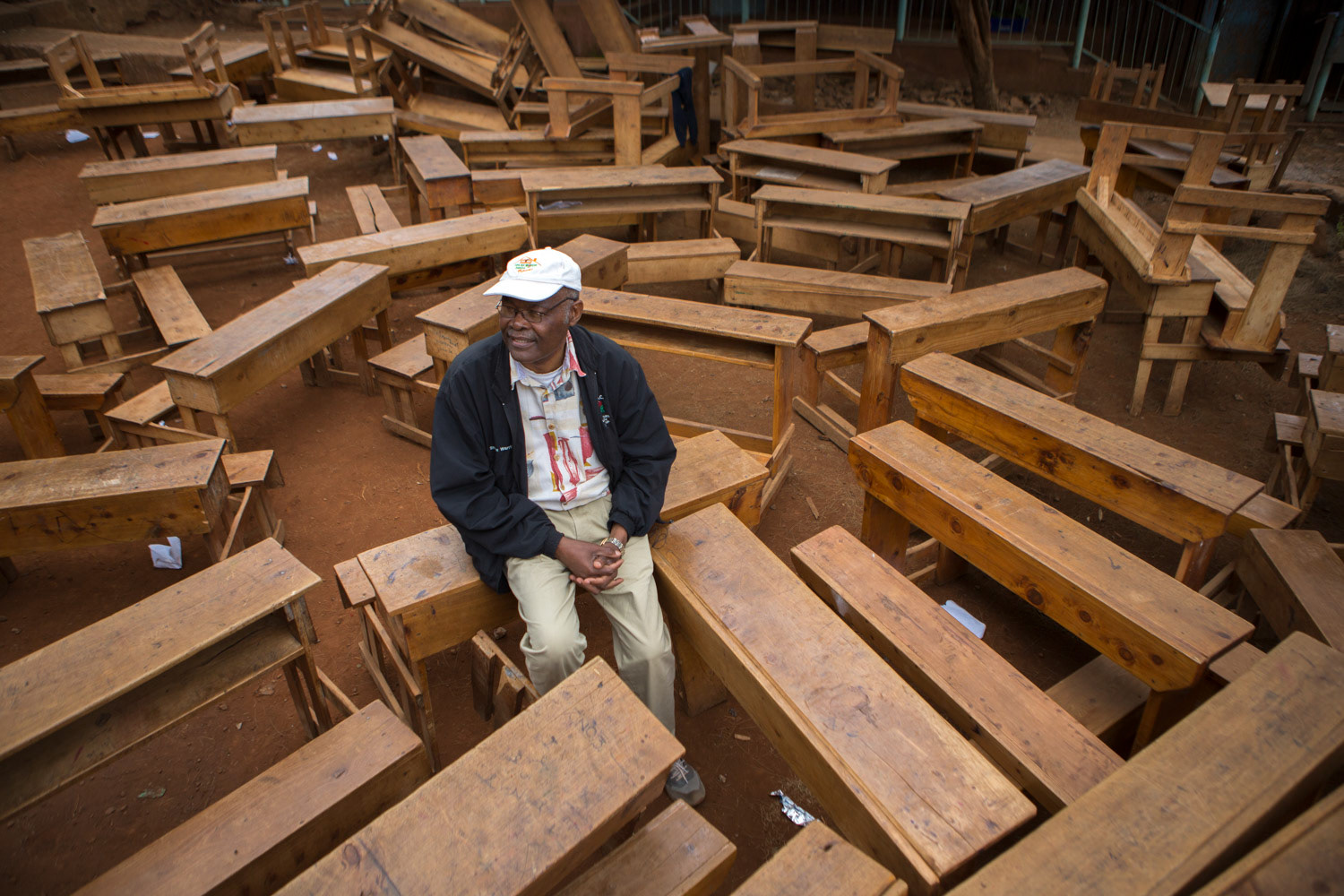 man sitting at school desks outside