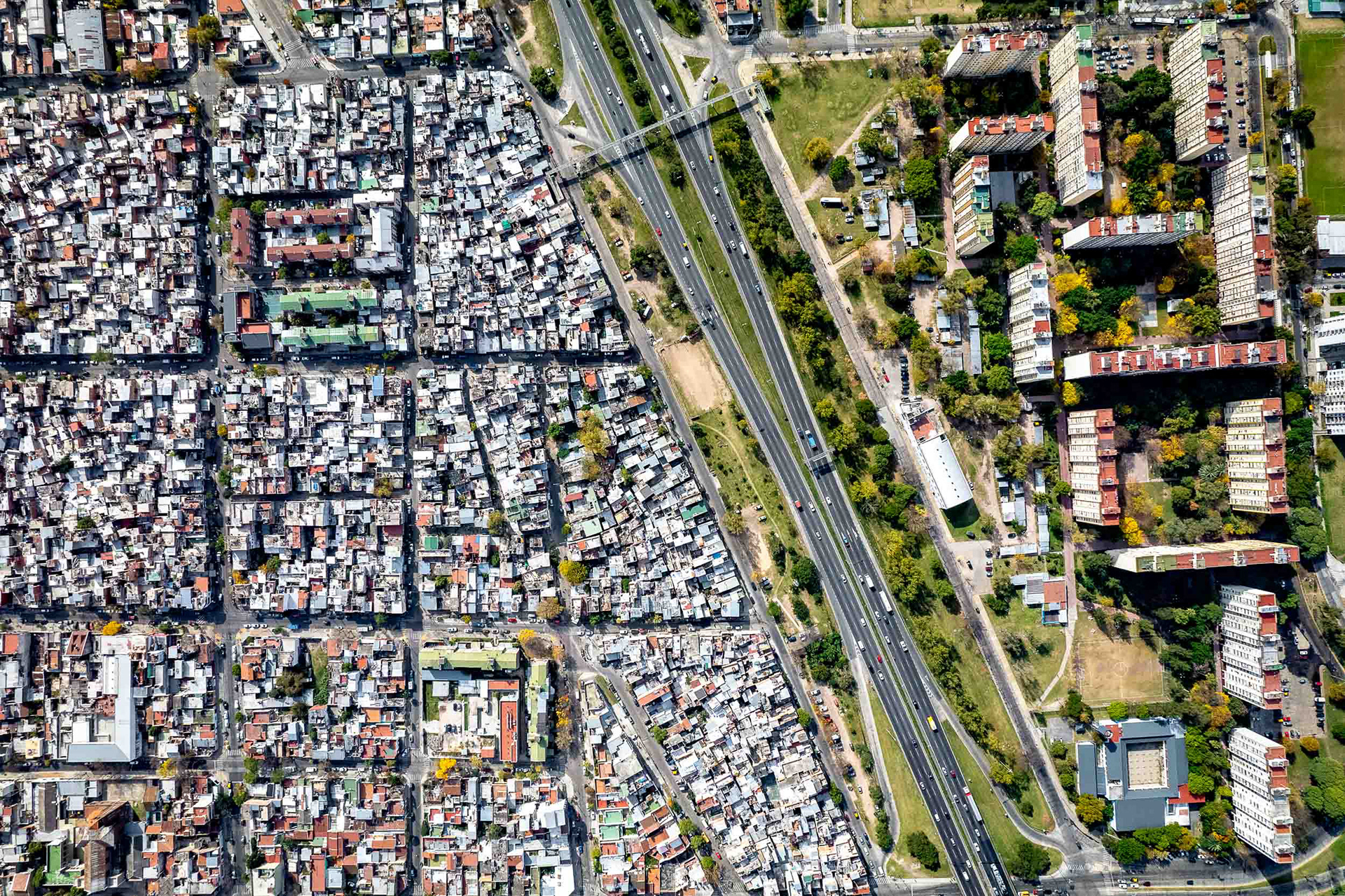 A drone photo of a slum next to a green area.
