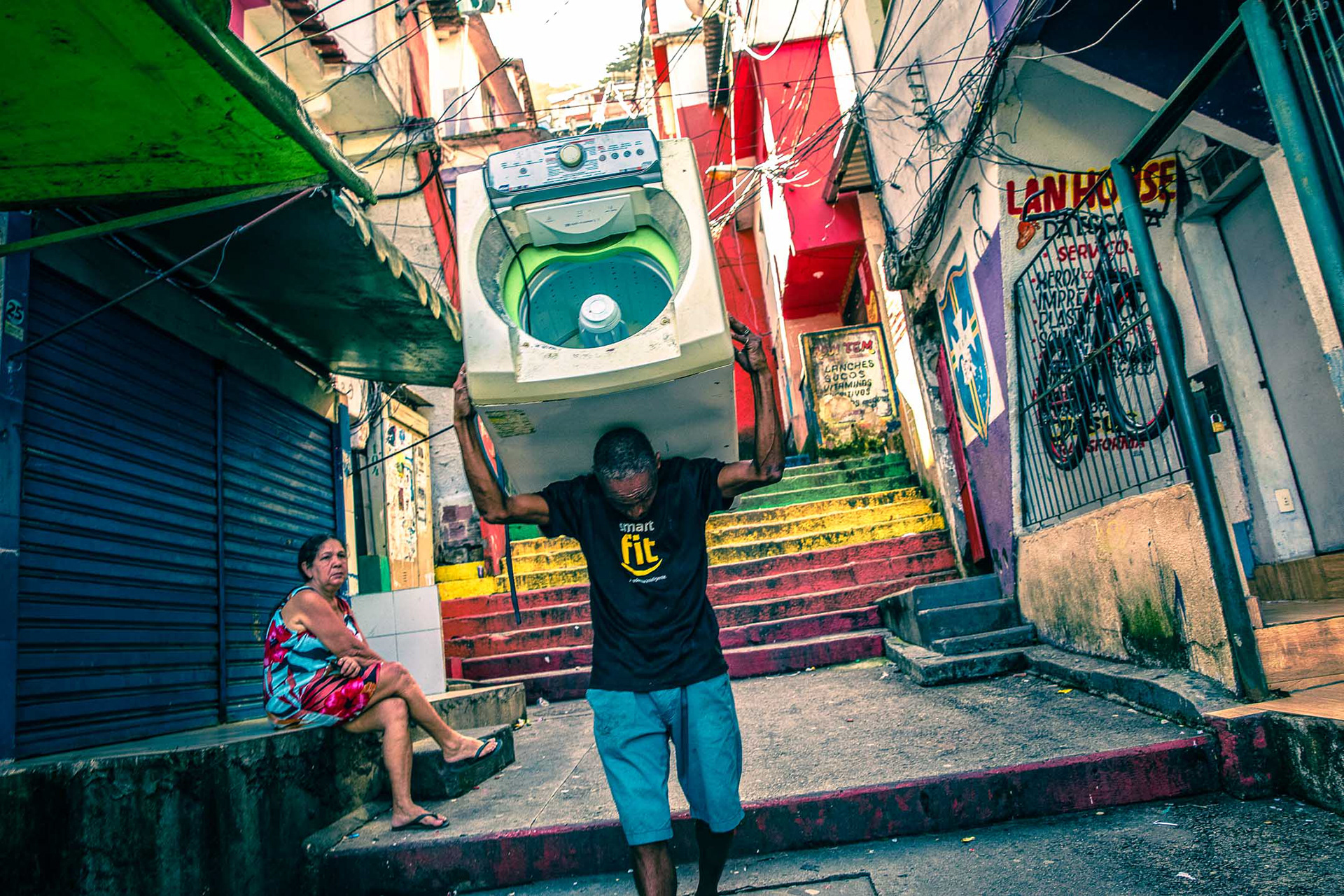 A man carries a washing machine on his shoulders in Rio's Santa Marta favela.