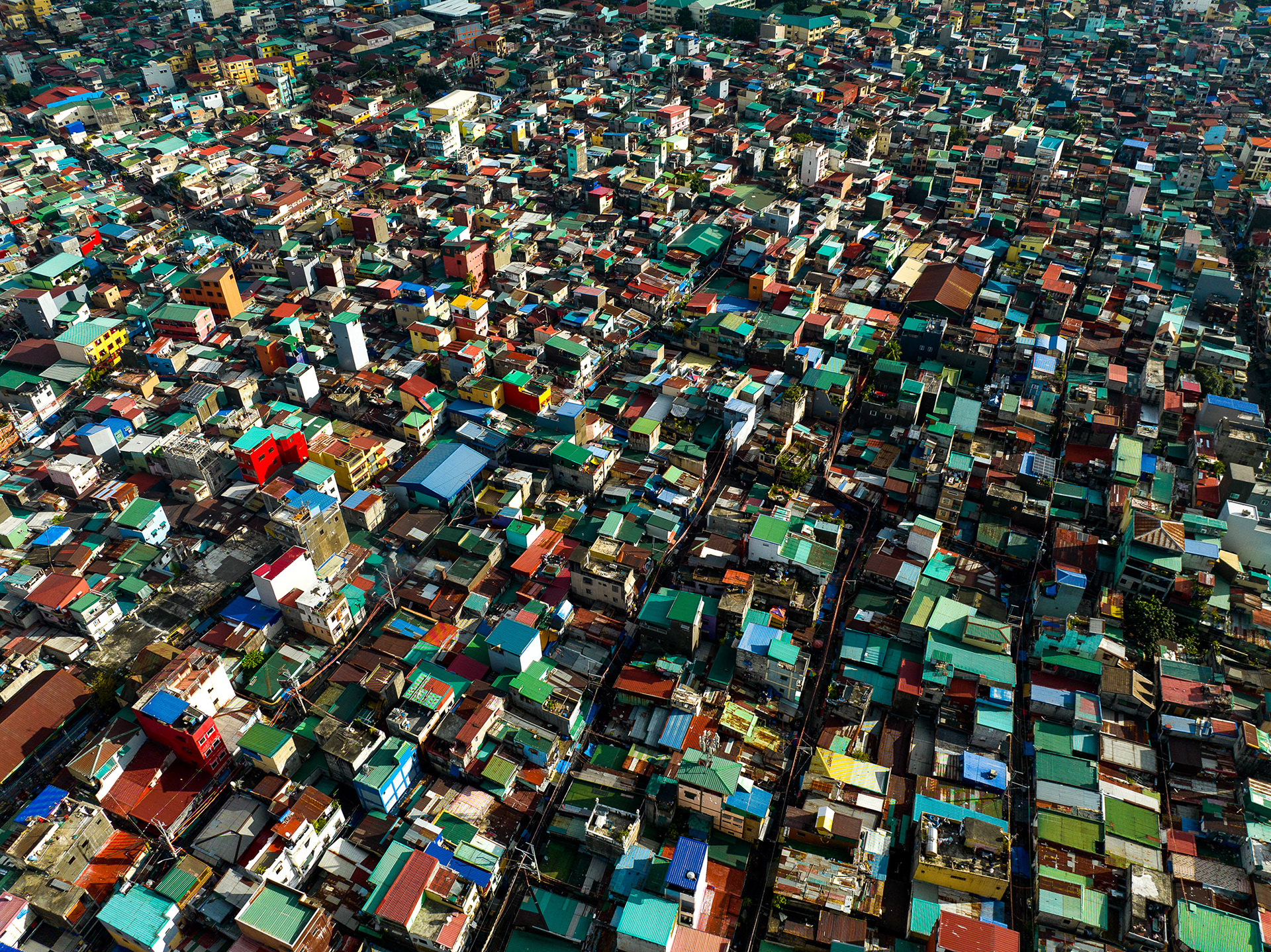 Top-down view of dense rooftops in Pembo, Manila, showing high population density and housing compression.