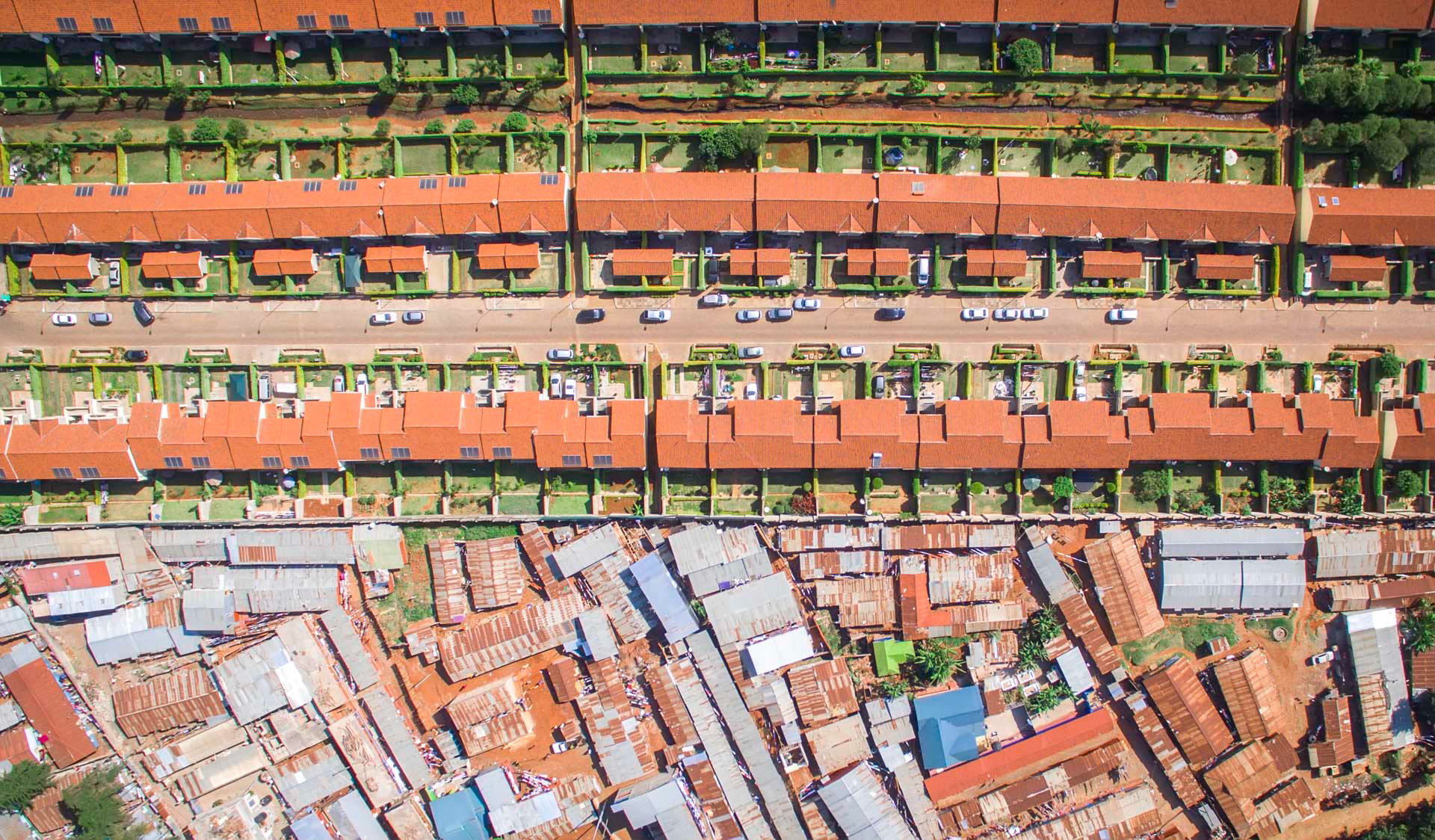 orange roof homes next to a wall and slums, nairobi