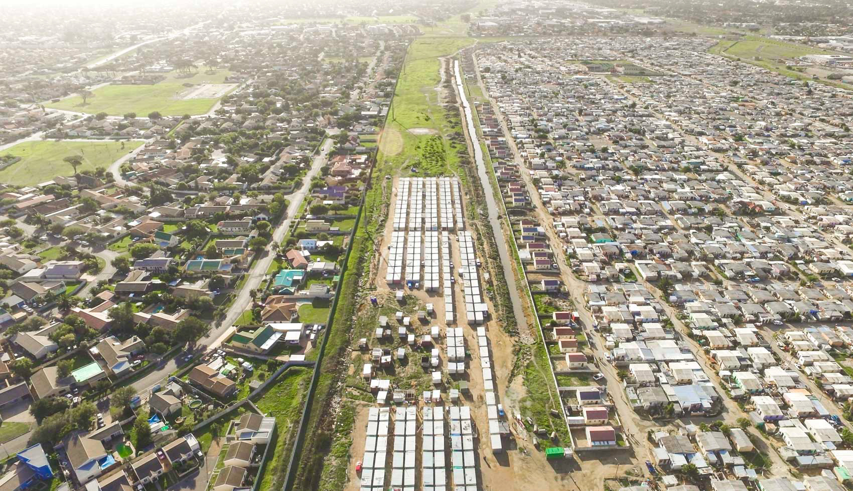 aerial view of shacks next to homes in cape town south africa
