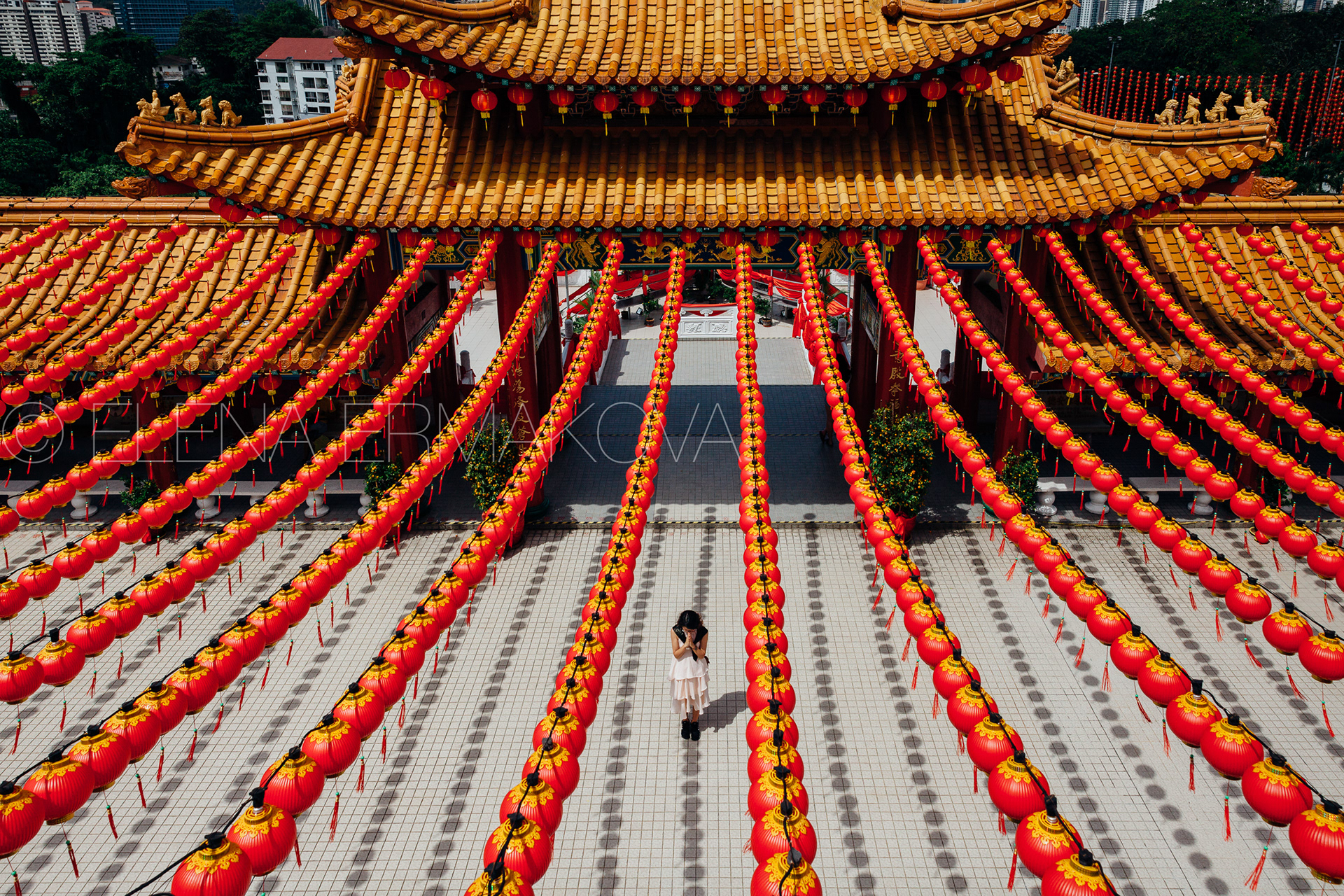 A young woman prays at the Thean Hou Temple decorated by lanterns for Chinese New Year