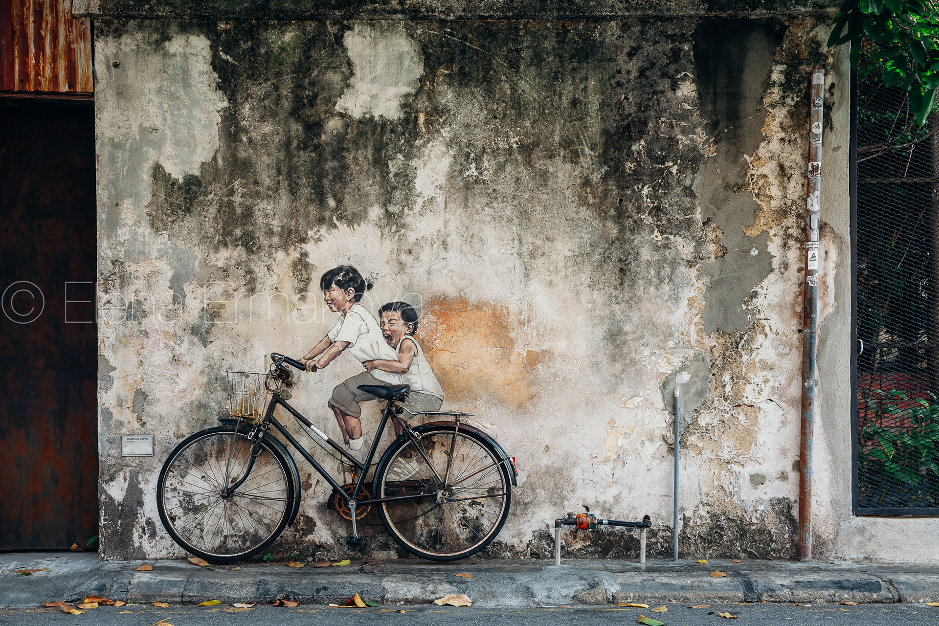 Famous creative Penang street art on the wall of UNESCO Heritage Buffer Zone, George Town, Penang, Malaysia. Travel photography by Elena Ermakova.