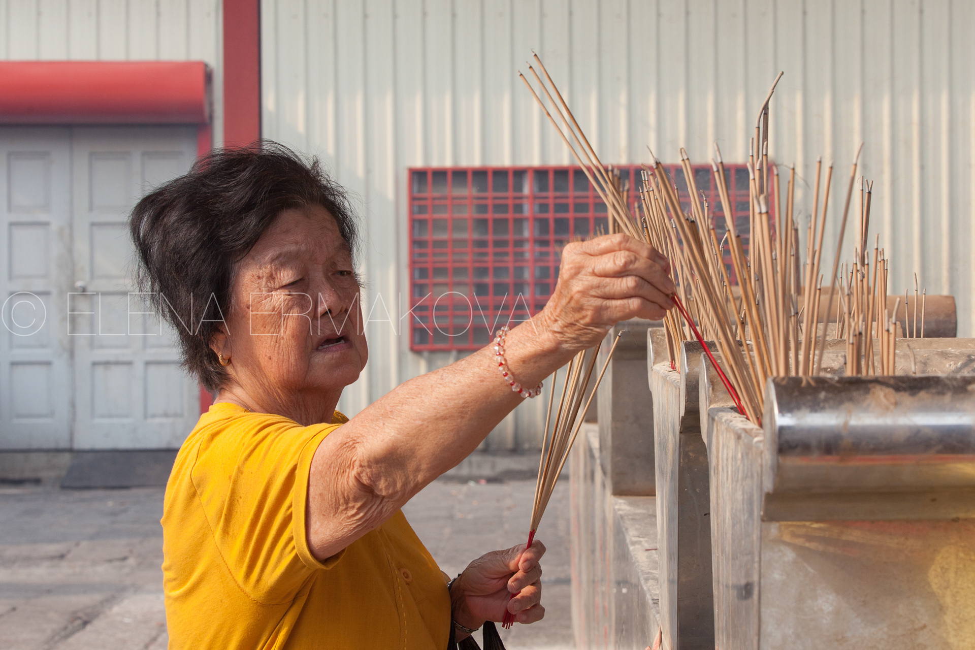 Woman burns incense in Kuan Yin Temple, one of the oldest Chinese temples on Penang, Malaysia