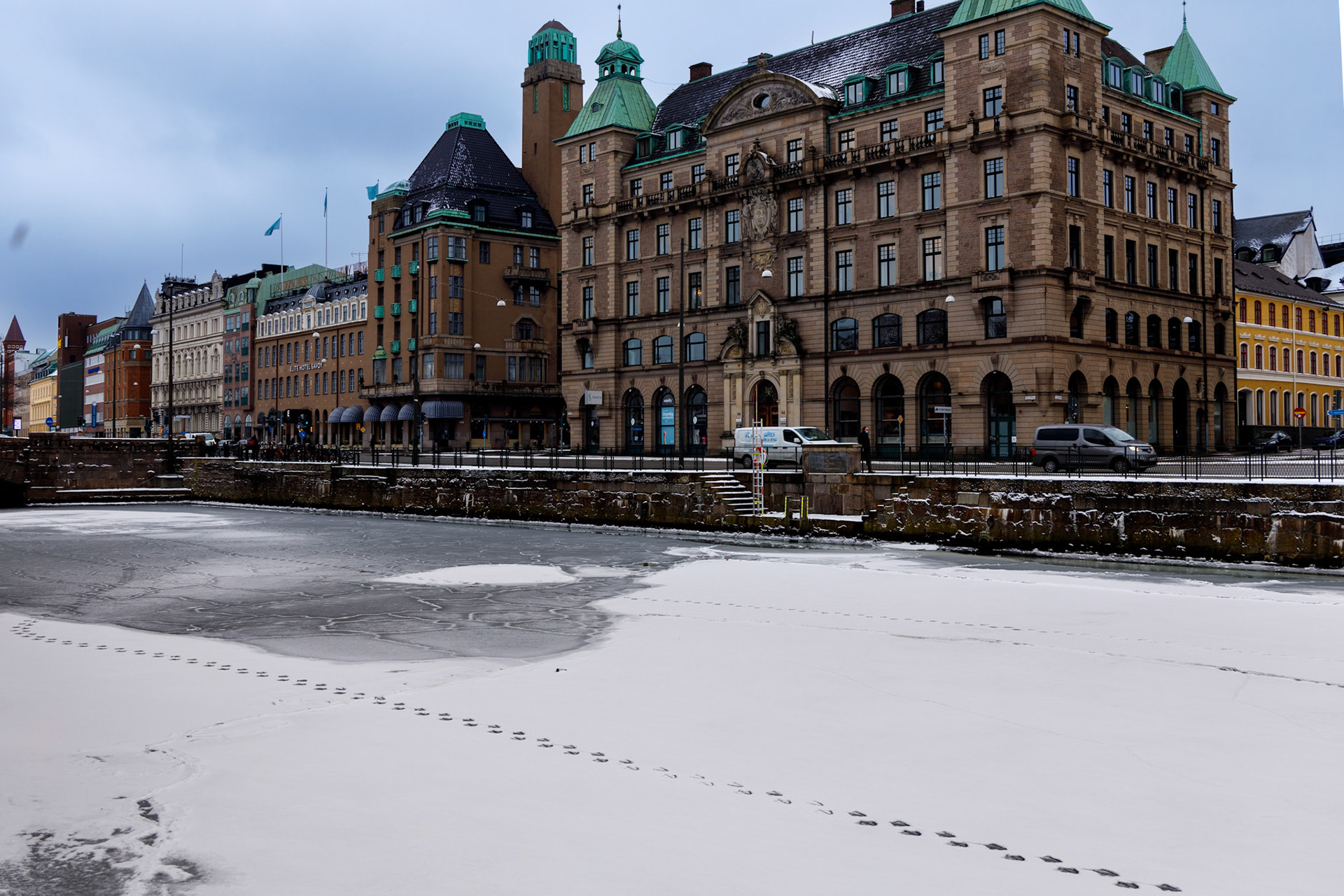 Det är inte ofta det är minusgrader i Malmö. Här har kanalen både frusit och blivit täckt av snö. Någon har gått på isen, troligen en större fågel.  Mälarbron är bakgrunden och till höger om det Hotell Savoy.