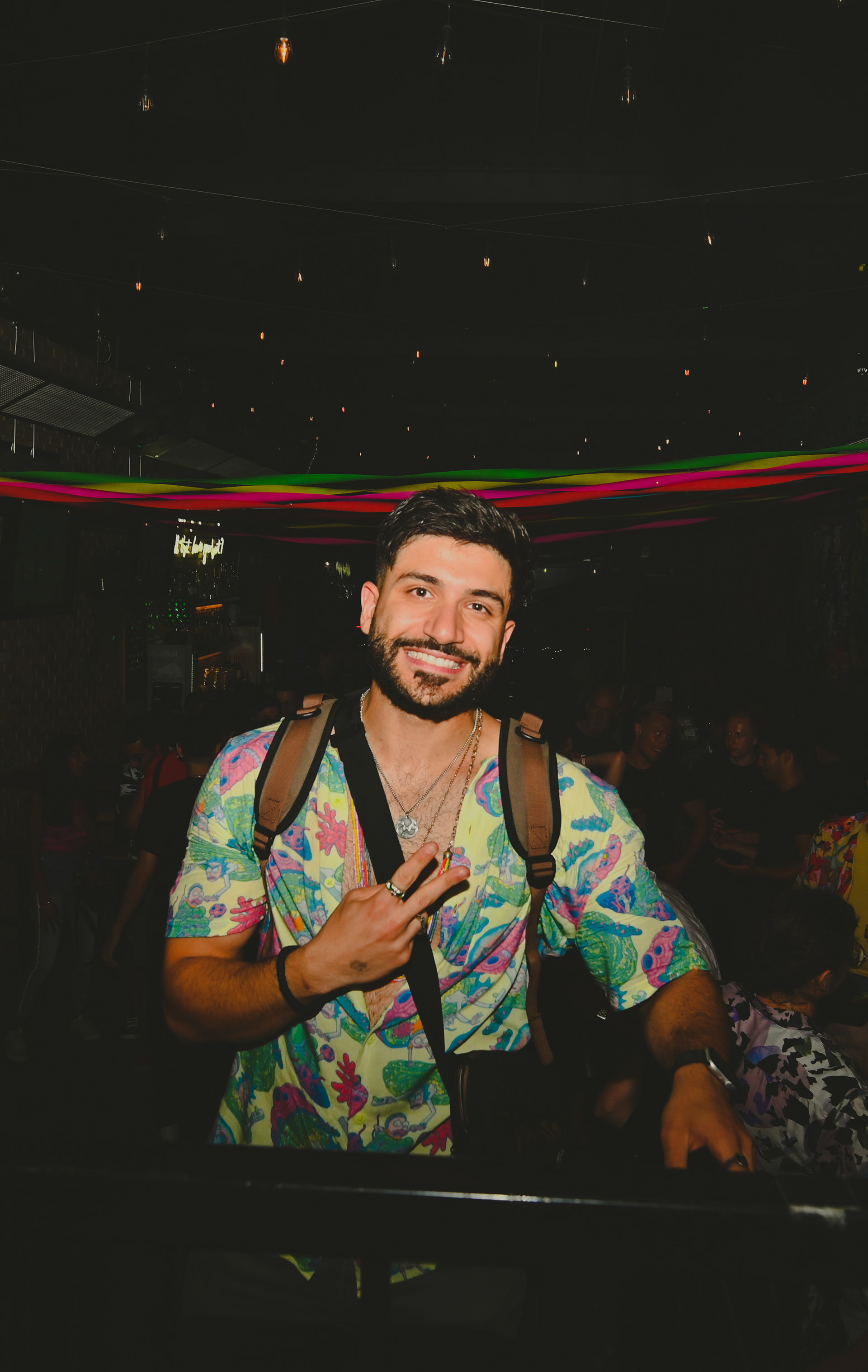 Hussain Al-Rikabi smiling and making a peace sign using his thumb and index fingers on his right hand